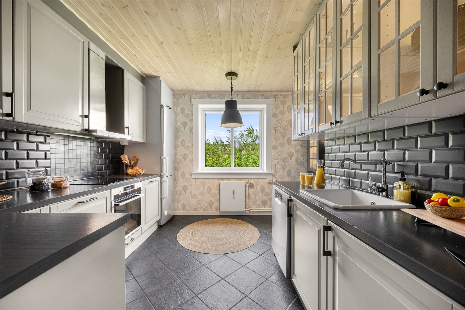 Praktisk kjøkken med innredningene profilerte fronter og heltre benkeplate med nedfelt kum. Galleribilde