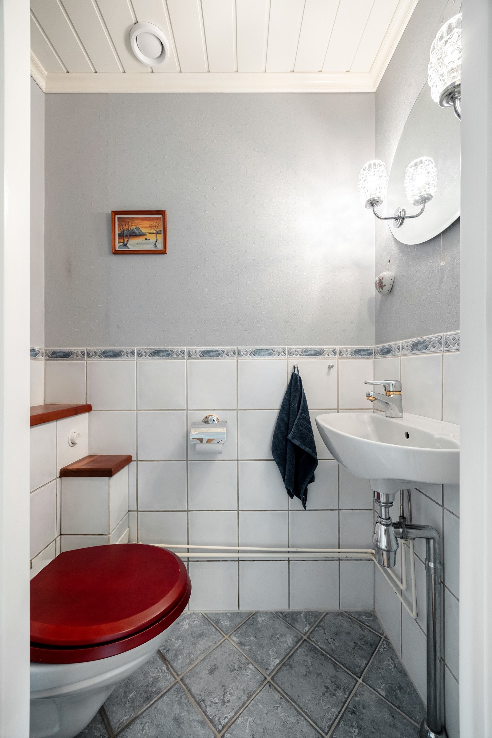 Toalettrommet ligger praktisk plassert i tilknytning til gangen og har flislagt gulv og vegger med dels flis og dels tapet. Galleribilde