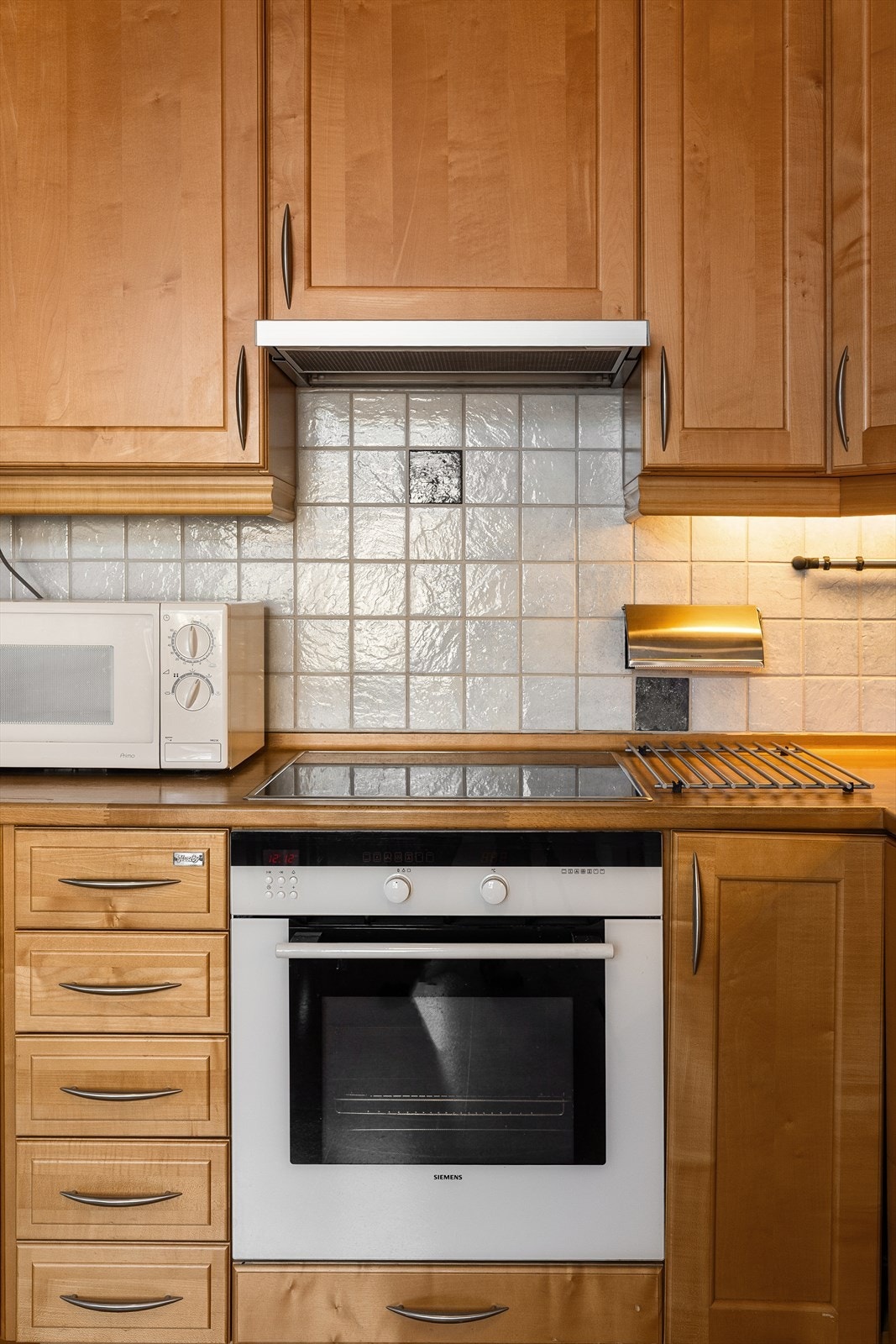 Kjøkkenet har heltre benkeplate og fliser over benk. Galleribilde