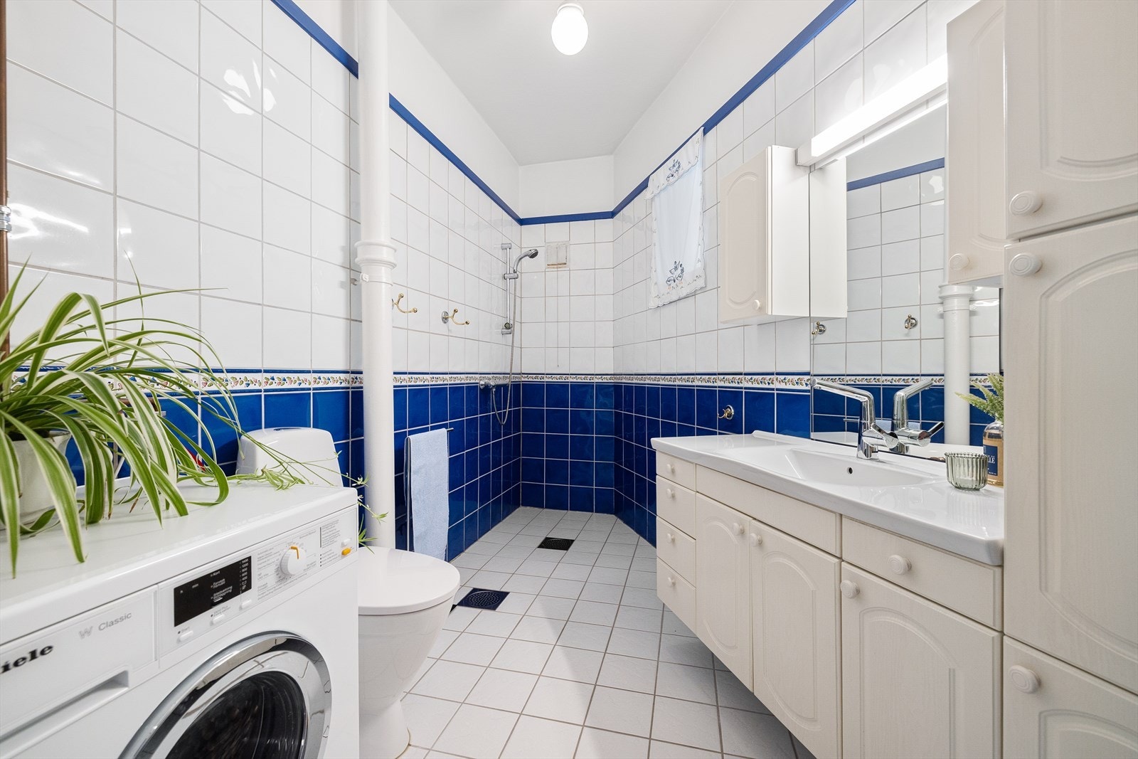 Praktisk og romslig baderom med elektrisk gulvvarme som gir en behagelig varme. Rommet har åpen dusjløsning med dusjhjørne, naturlig avtrekk, opplegg for vaskemaskin, vegghengt bereder og lett tilgjengelig stoppekran. Galleribilde