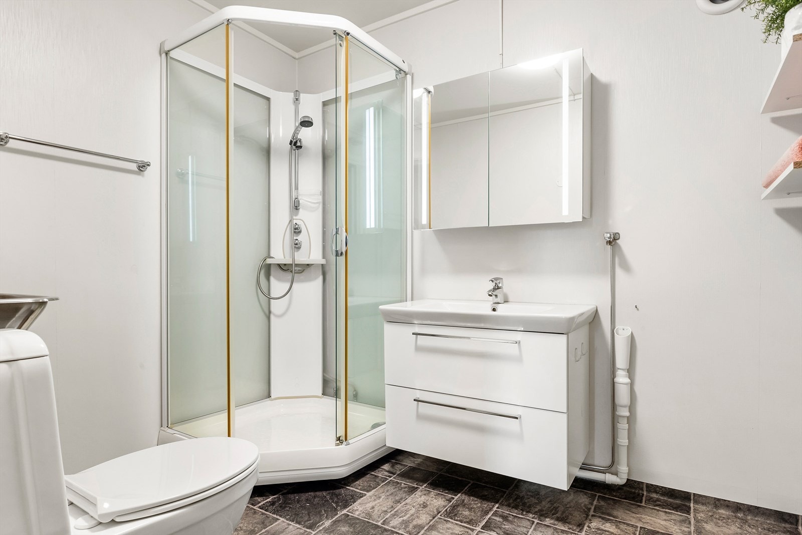 Baderommet holder enkel standard men innehar de kvaliteter man trenger; toalett, dusjkabinett, opplegg for vaskemaskin, skyllekar og baderomsinnredning med nedfelt servant. Galleribilde