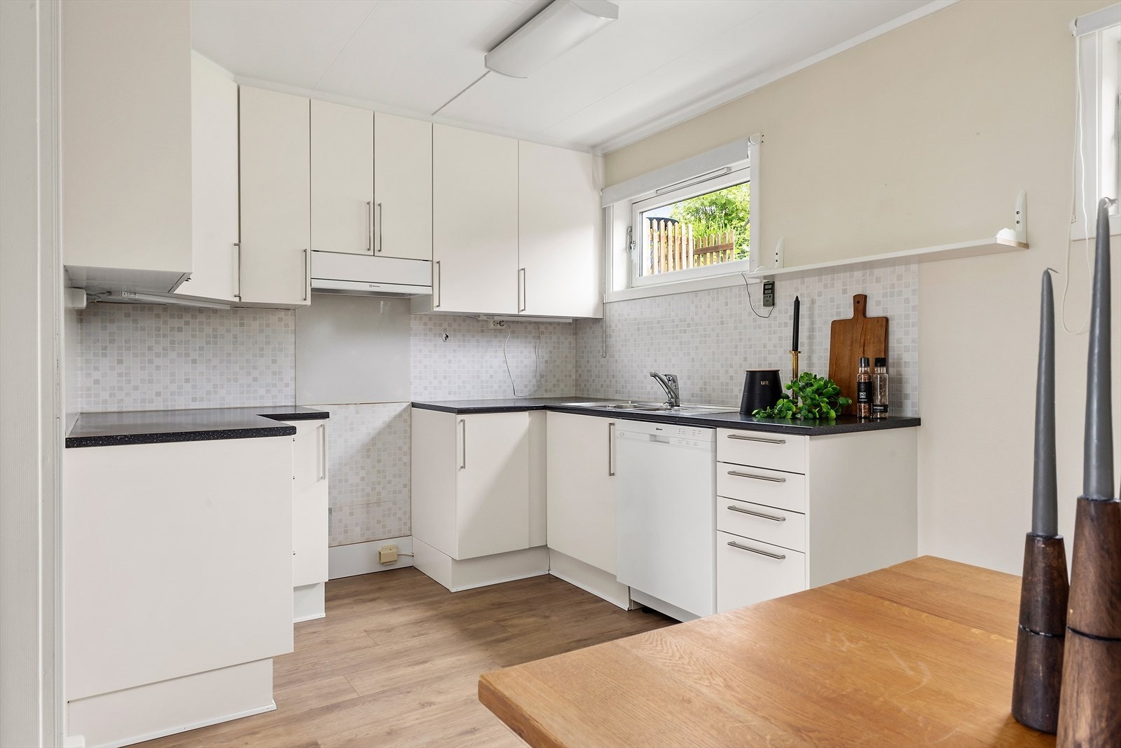 Kjøkkenet har takhøy innredning og godt med skap- og benkeplass Galleribilde