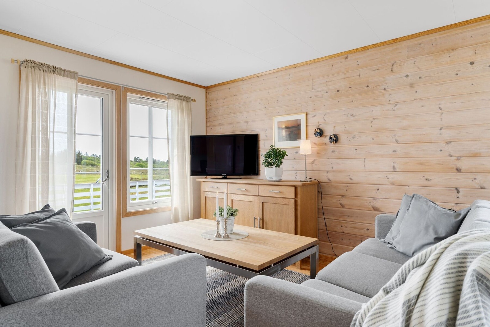 Stua har store vindusflater som tilfører rikelig med dagslys Galleribilde