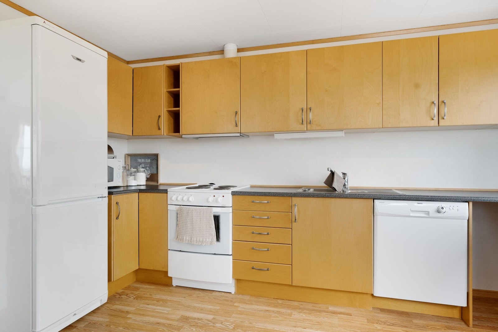 Kjøkkenet er utstyrt med bl.a. kompiskap/kjøleskap, oppvaskmaskin og komfyr. Hvitevarer medfølger i handelen. Galleribilde