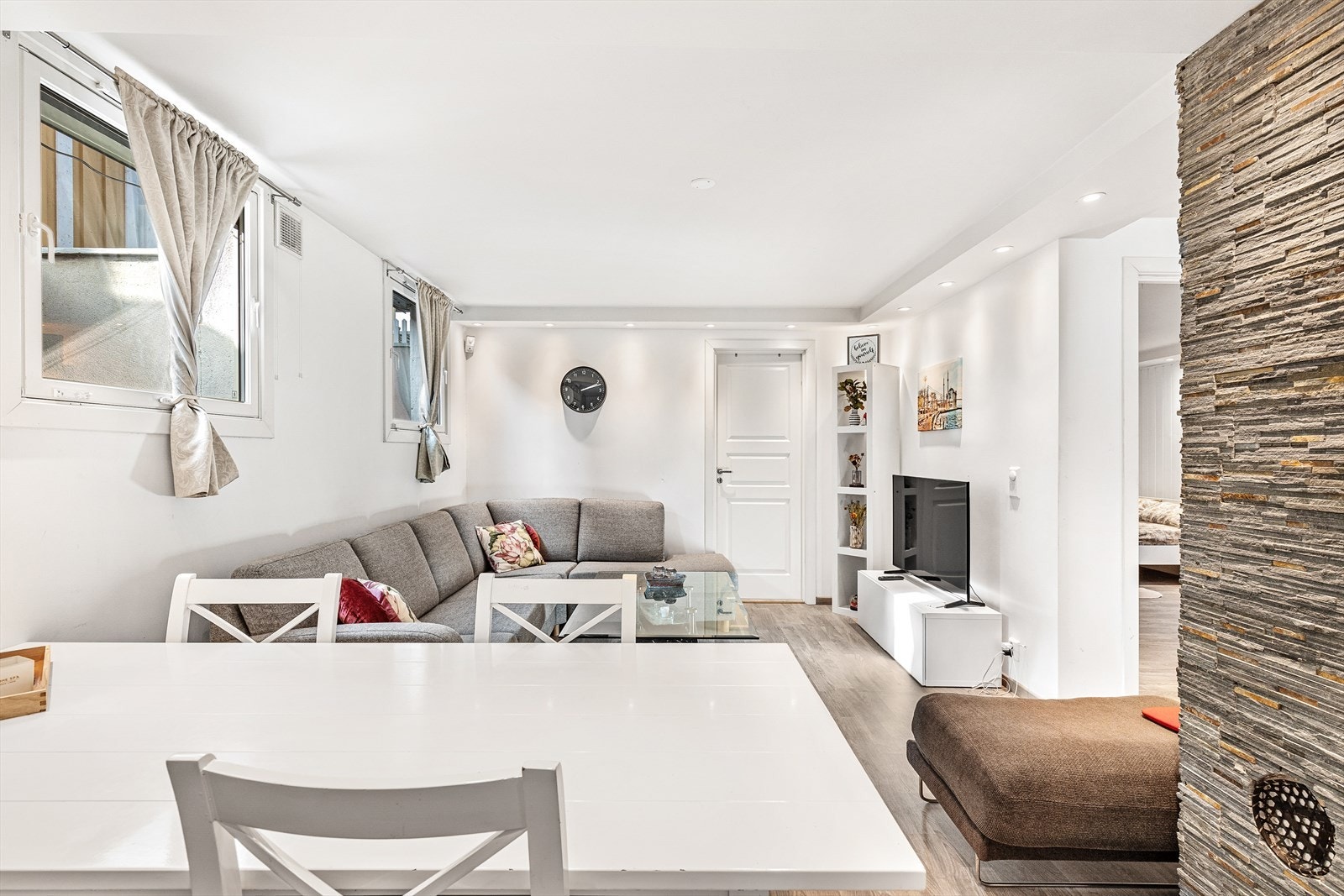 Stuen har god plass til sofa og tv-møblement og har hvitmalte overflater og downlights i tak Galleribilde