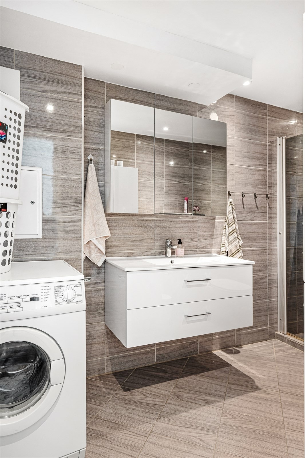 Videre inneholder badet vegghengt toalett, dusjnisje, vask og opplegg til vaskemaskin Galleribilde