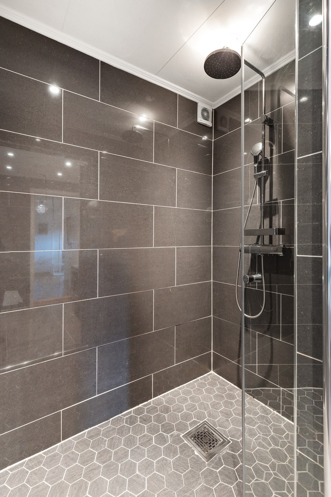 Badet består av dusjnisje med regnfallsdusj og glassdører, elektrisk boblekar, vask og vegghengt toalett Galleribilde