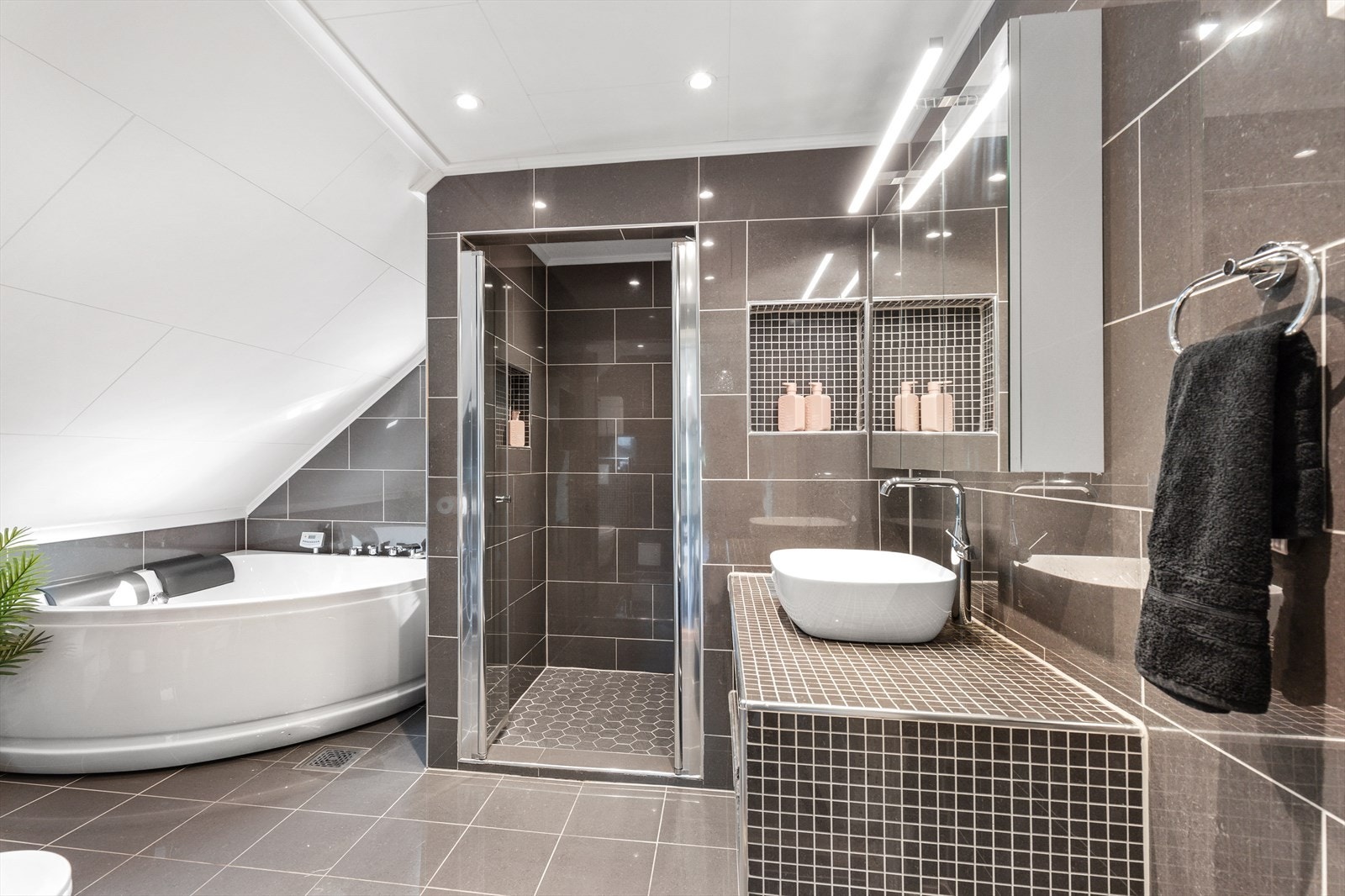 Boligens 2.etasje har et stort bad fra 2019 med flislagt gulv med varmekabler og vegger, samt hvite plater i tak Galleribilde