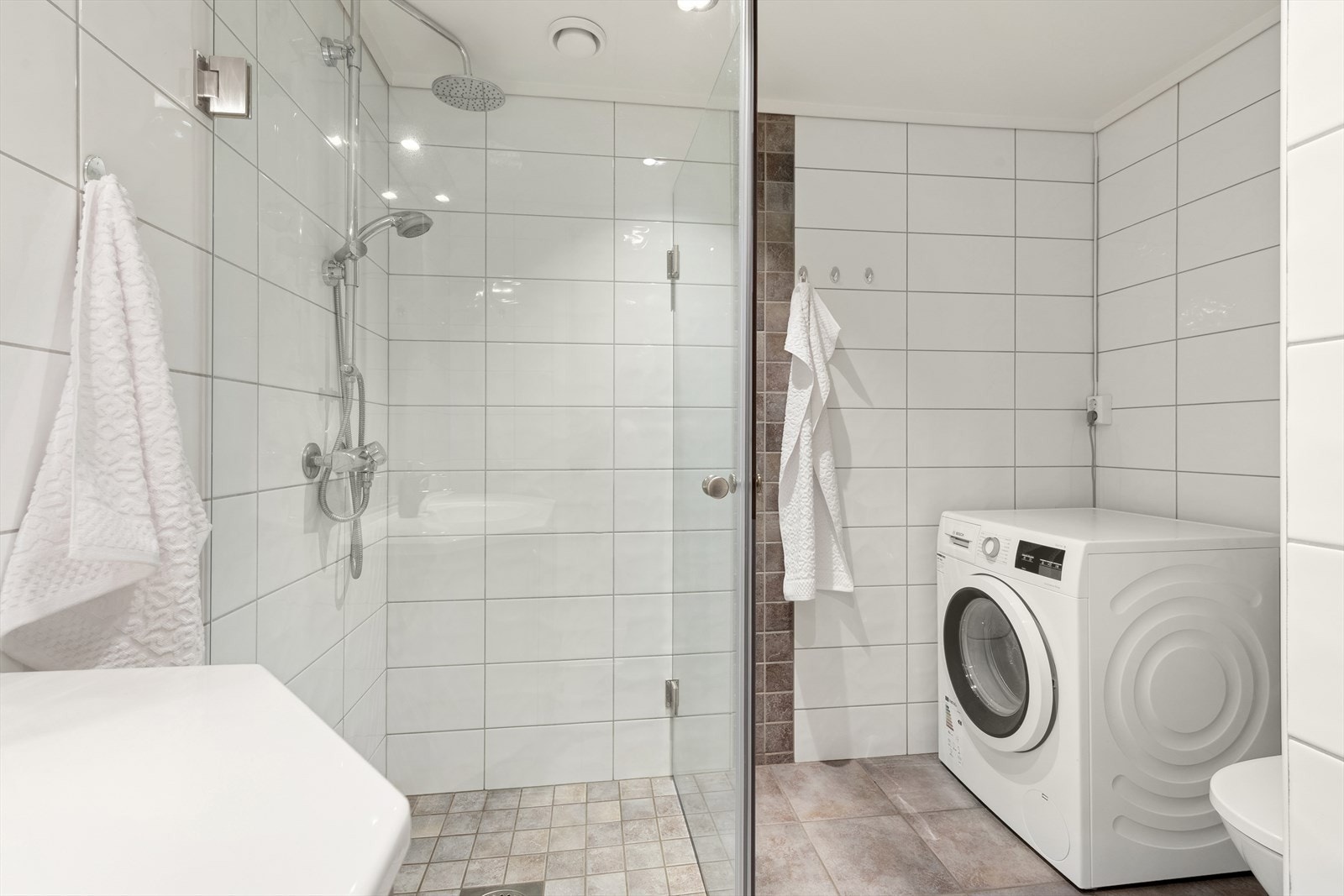 Rommet har flislagte overflater i et tidløst fargevalg og komfortabel varme i gulv, som bidrar til å gi en god start på dagen. Galleribilde