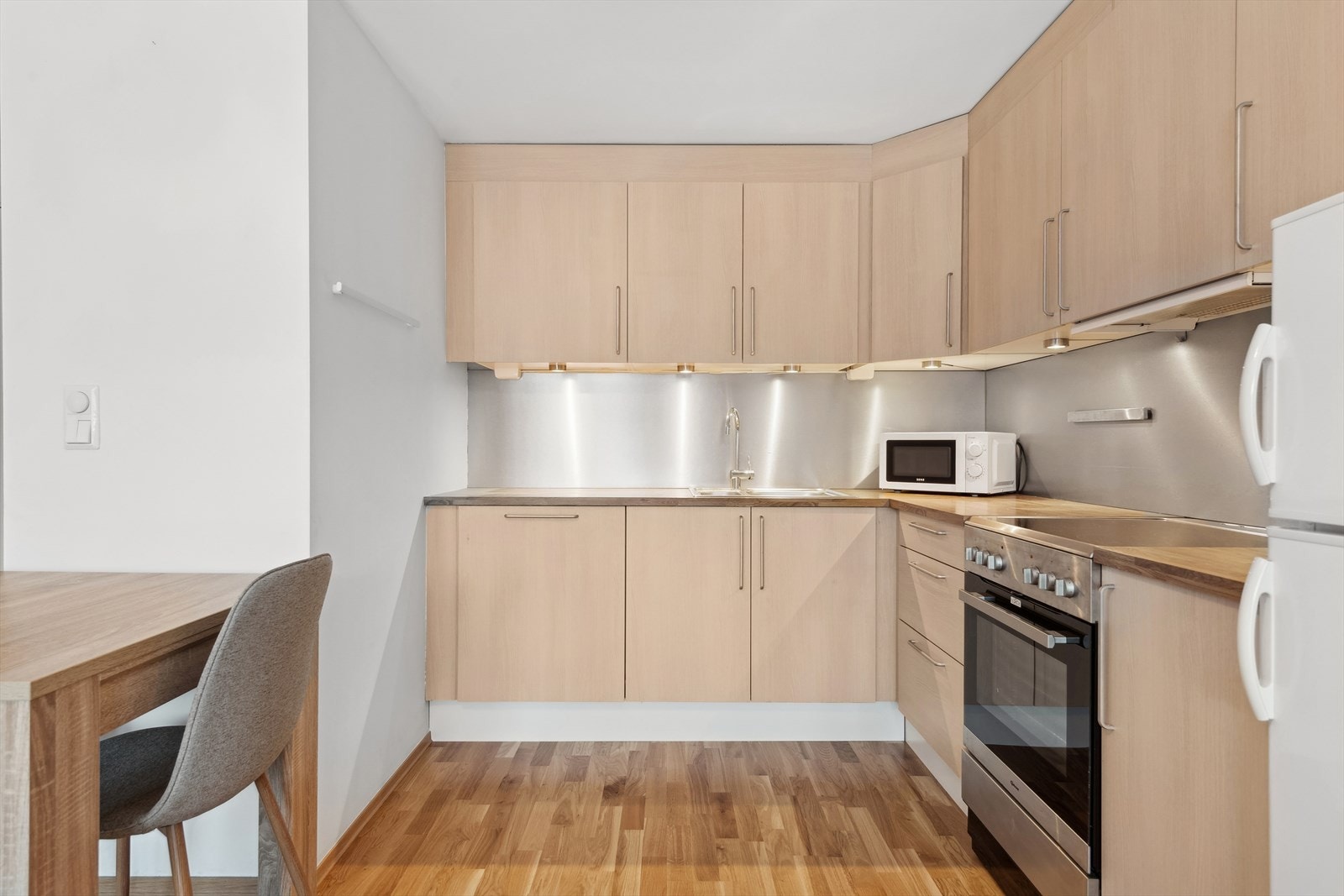 Innredning med glatte fronter, og laminat benkeplate hvor det er montert kjøkkenvask med både stor og liten kum. Galleribilde