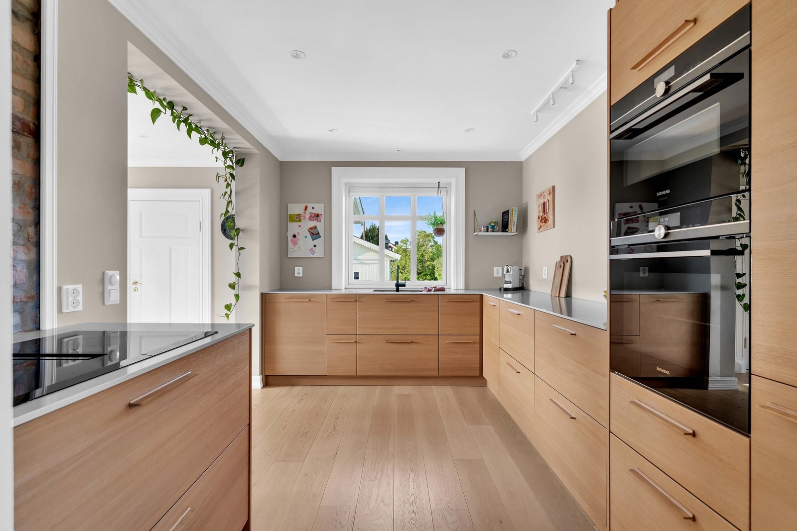 Kvikkjøkken med integrerte hvitevarer som mikrobølgeovn, stekeovn, nedfelt stekeplate og kombiskap. Galleribilde