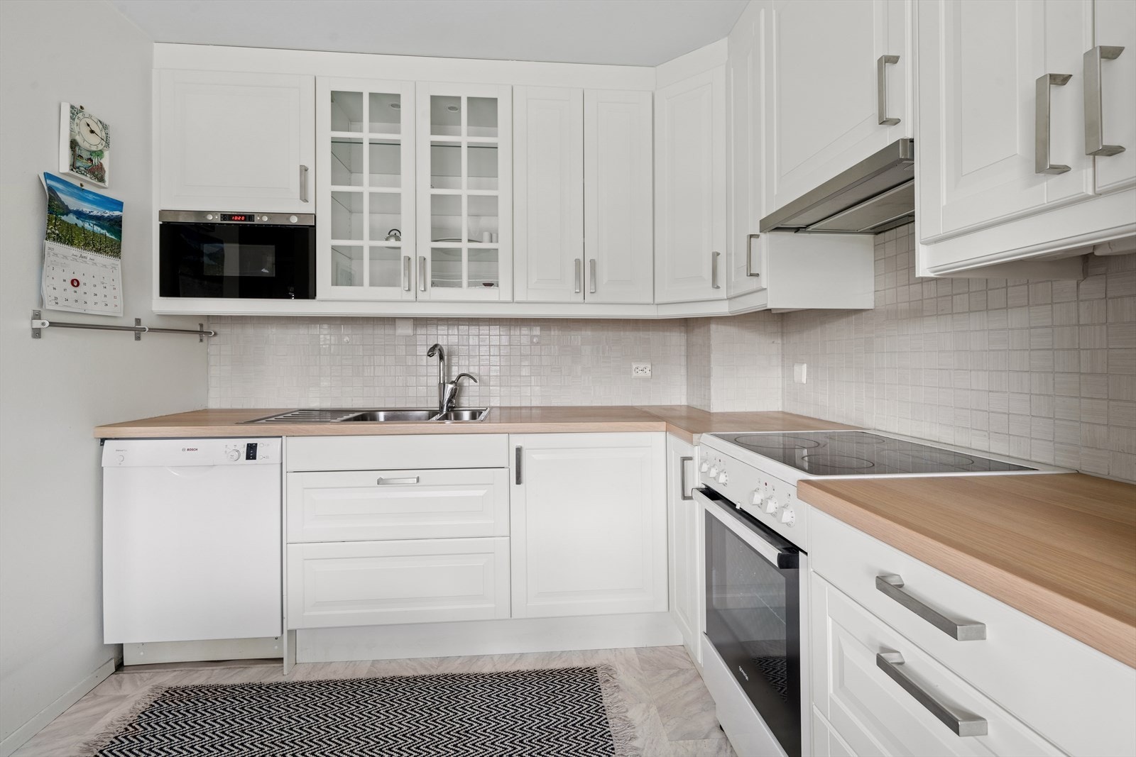 Over den laminatbelagte benkeplaten med nedfelt oppvaskkum og 1-greps blandebatteri er det fliser og belysning som gir både funksjon og stil. Galleribilde