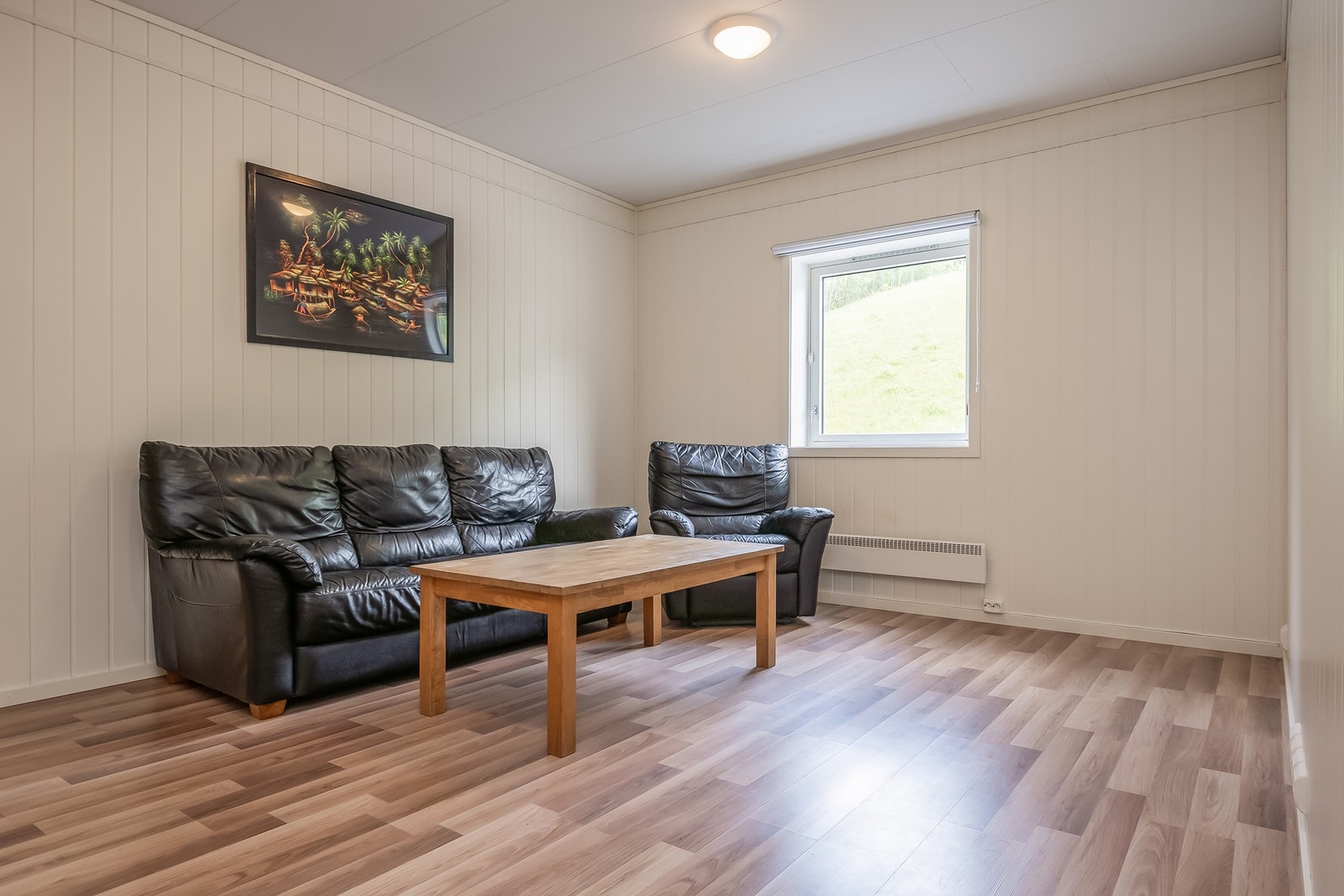 Romslig stue og kjøkken som sammen måles til 24,7 kvm. Denne delen av boligen ble pusset opp i 2018. Galleribilde