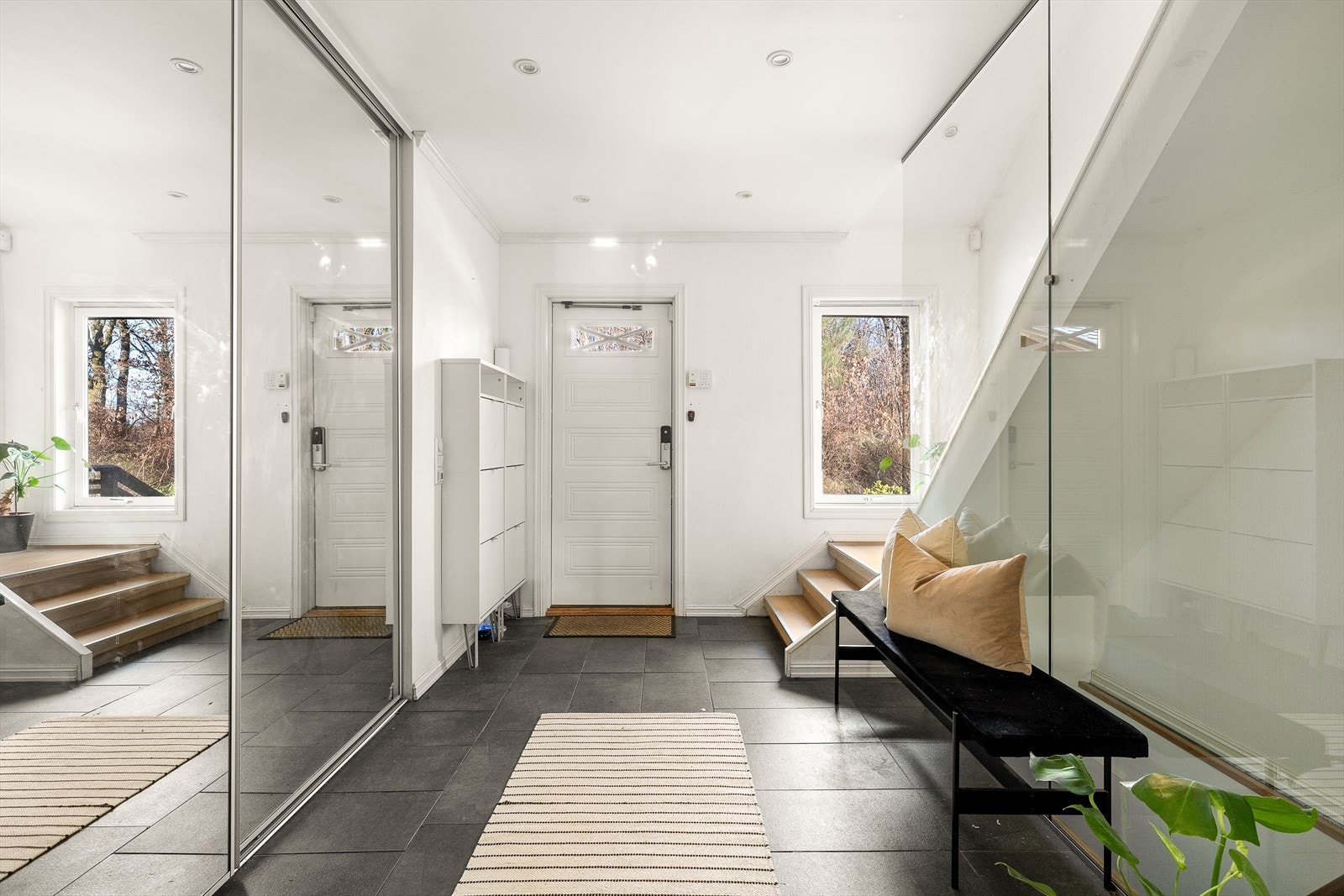 Romslig og innbydende gang med flislagt gulv og integrert skyvedørsgarderobe, som gir rikelig med oppbevaringsplass for yttertøy og sko Galleribilde