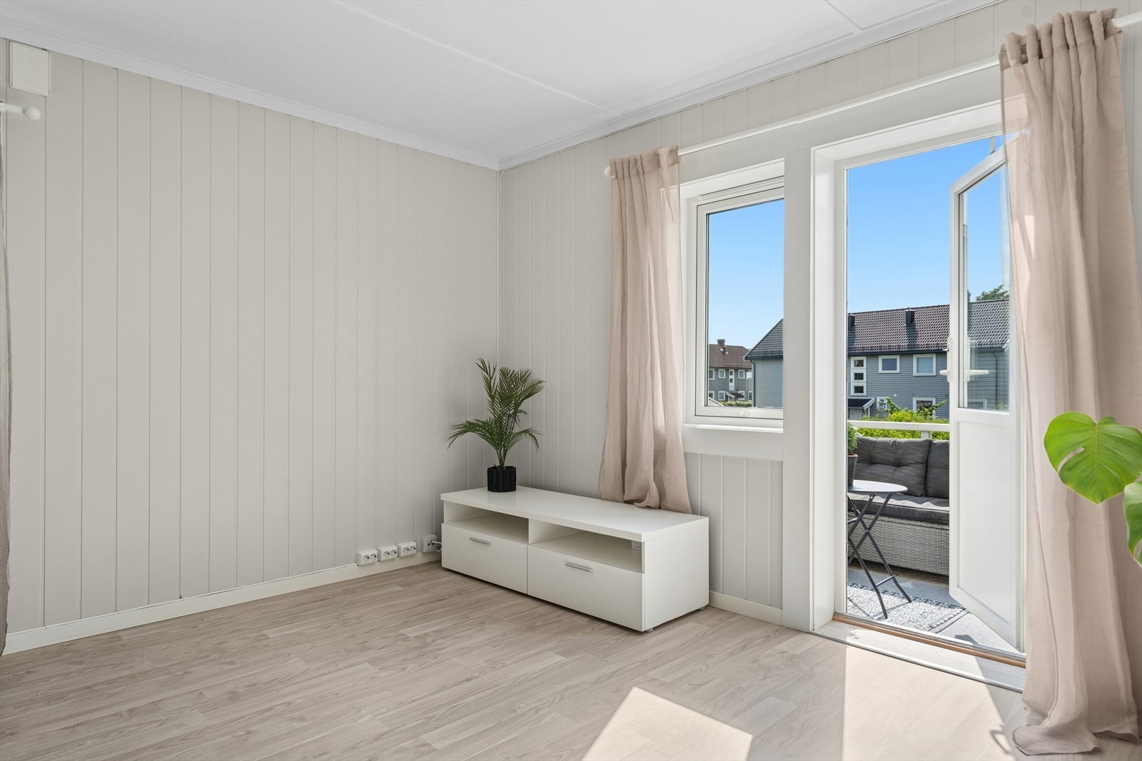 Stuen har pene laminatgulv og lysmalte vegger. Galleribilde
