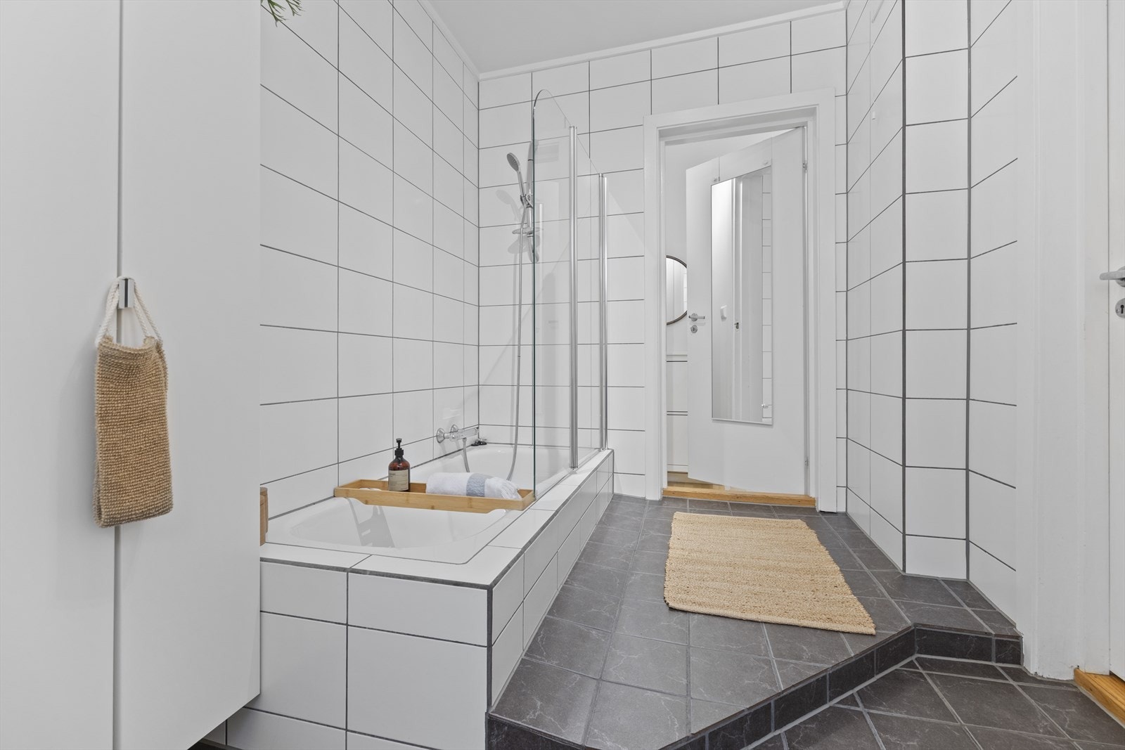 Servant/skap, toalett, innmurt badekar, speilskap og opplegg til vaskemaskin. Galleribilde