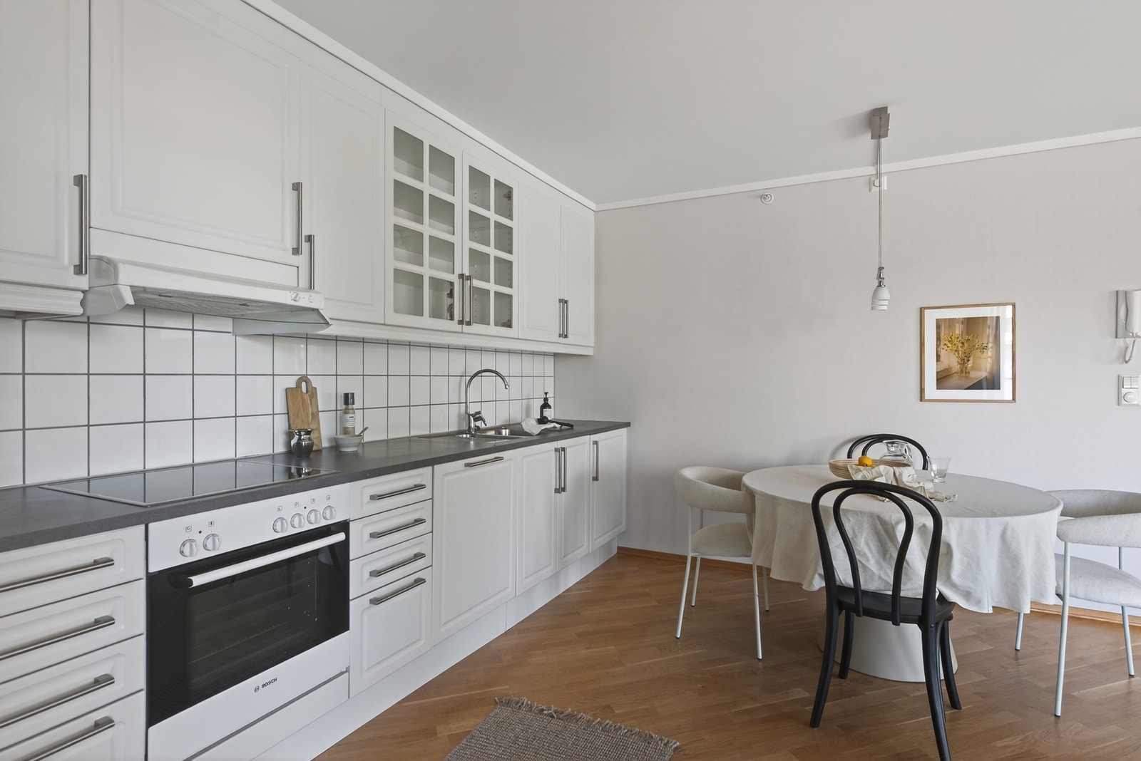 På kjøkkenet har du lyse profilerte fronter og praktiske fliser mellom kjøkkenbenk og overskap Galleribilde