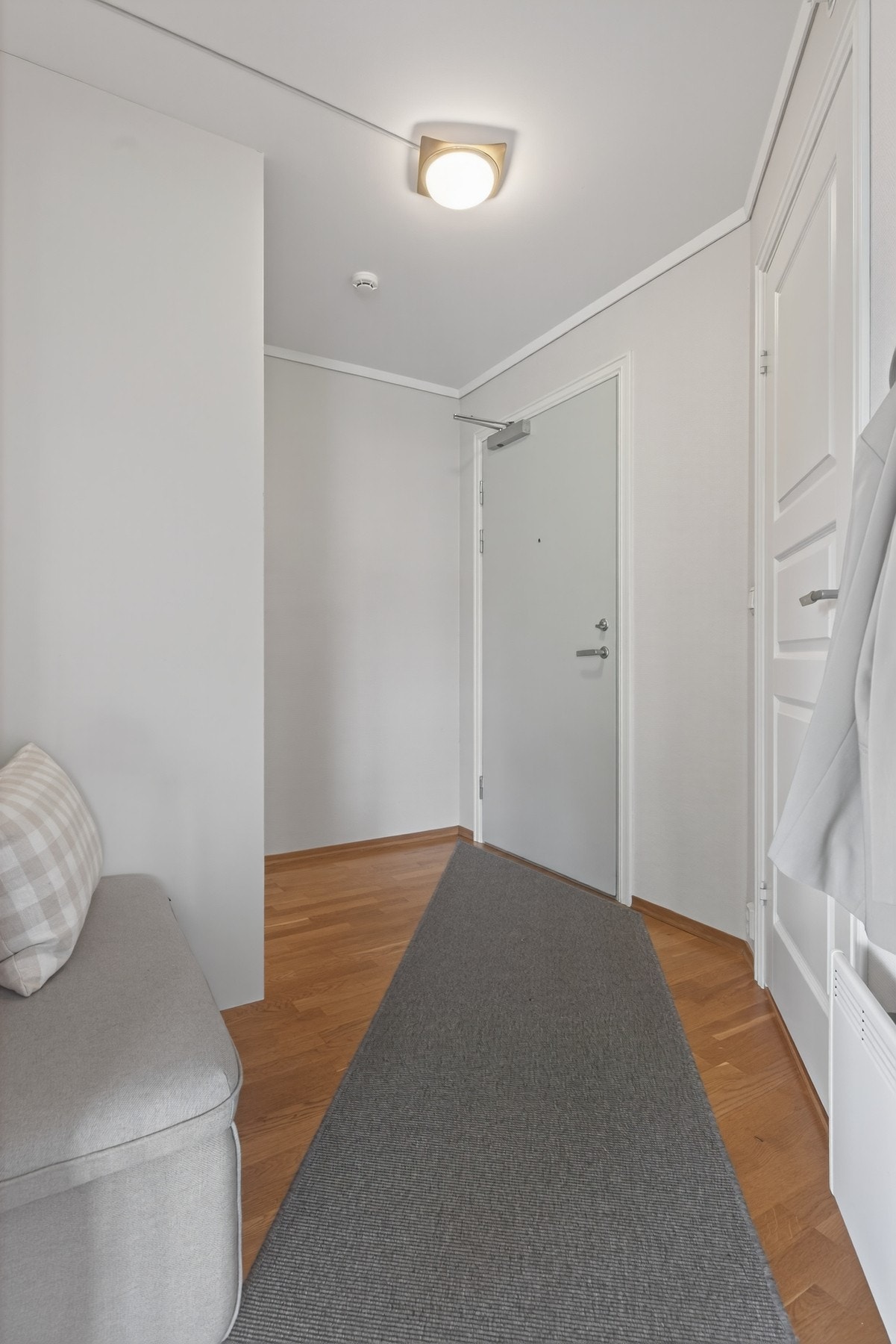 Her kommer du inn i en lys entré med praktisk skyvedørsgarderobe for ryddig oppbevaring av sko og jakker Galleribilde