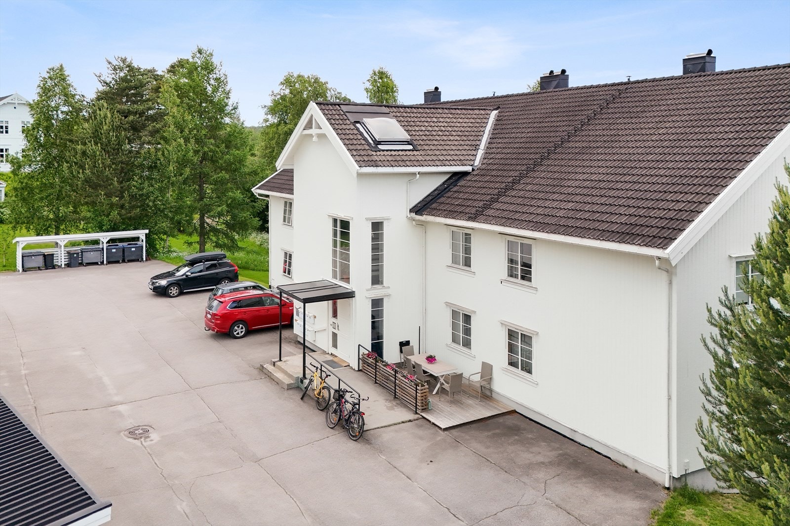 Asfaltert gårdsplass og felles garasjeanlegg med en plass tilhørende leiligheten. Galleribilde