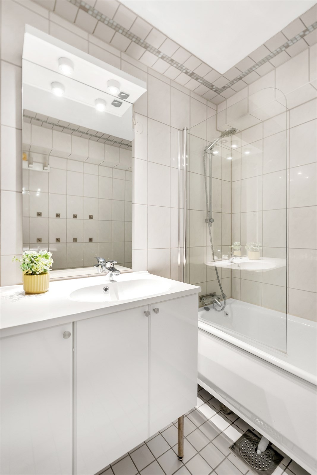Badekar med dusj-vegg fra 2024.
Baderoms-innredning med servant-skap, speil med lys Galleribilde