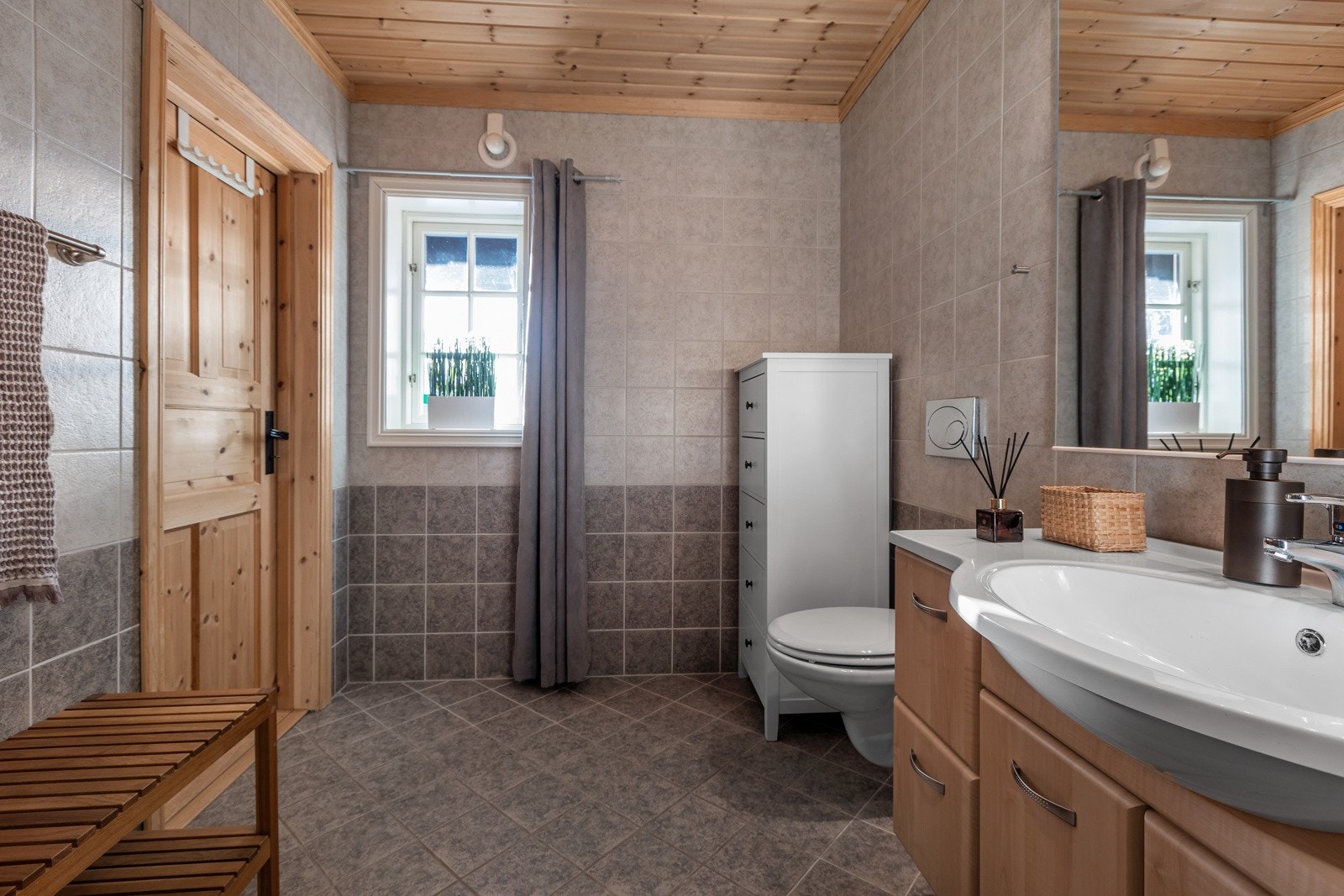 Bad 2 i 1.etasjen- her er det også flislagt gulv og vegger og innredet med servantskap, vegghengt toalett og speilskap Galleribilde