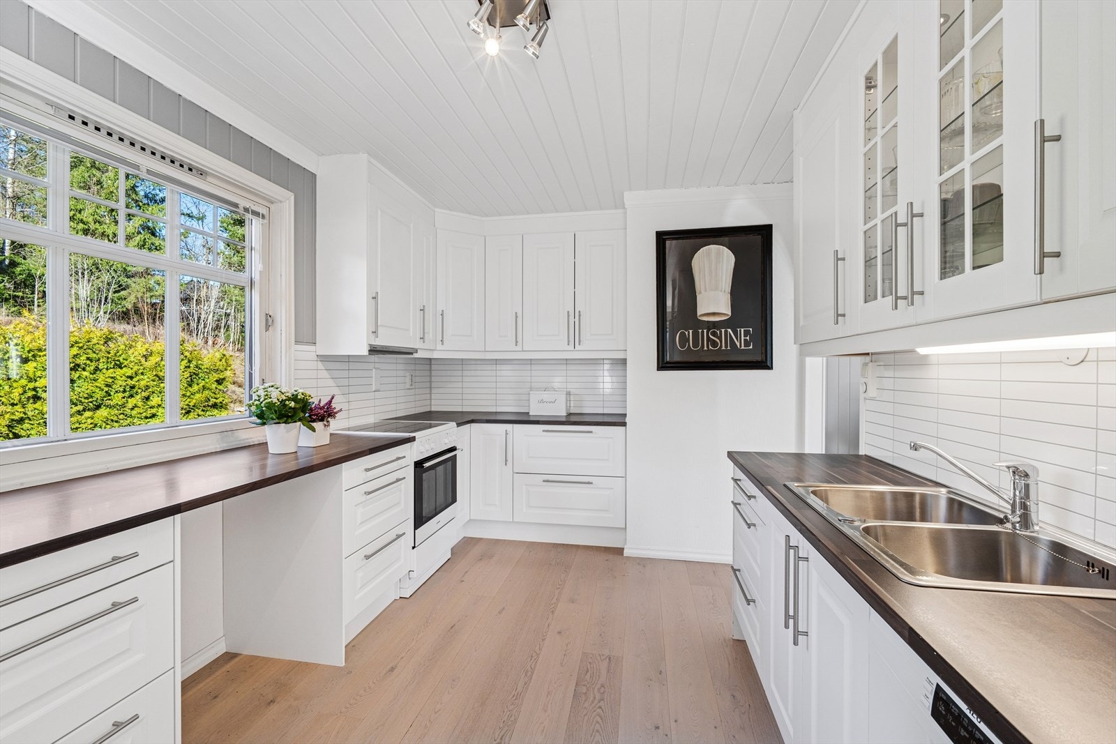 Kjøkkeninnredning er 2013, med malte profilerte fronter og laminerte benkeplate. Store vindusflater på kjøkkenet slipper inn rikelig med naturlig lys inn. Galleribilde