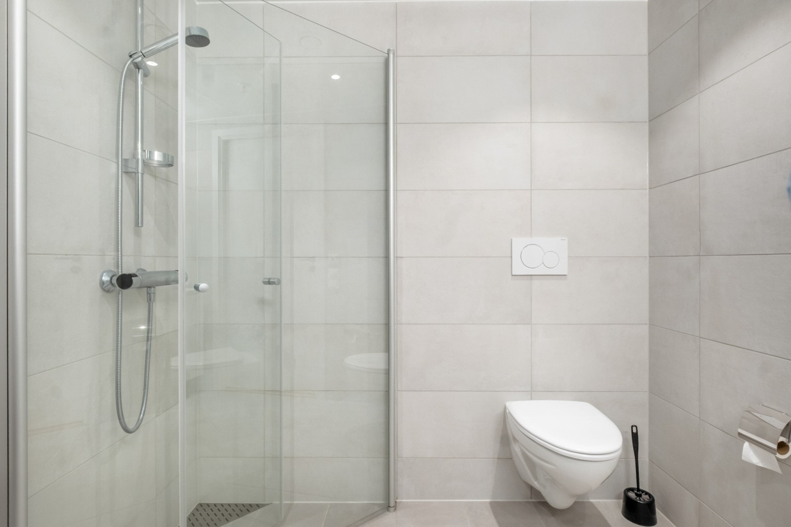 Moderne bad med lyse farger med gulvvarme, dusjvegger, wc og downlights. Galleribilde