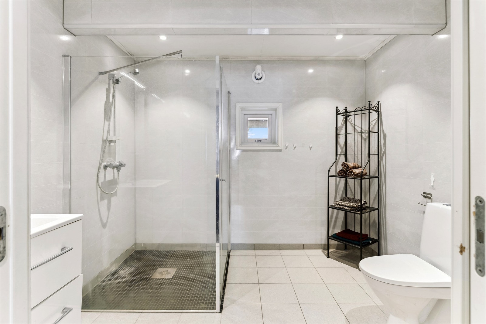 Bad fra 2017 med fliser på gulv og elektriske varmekabler Galleribilde