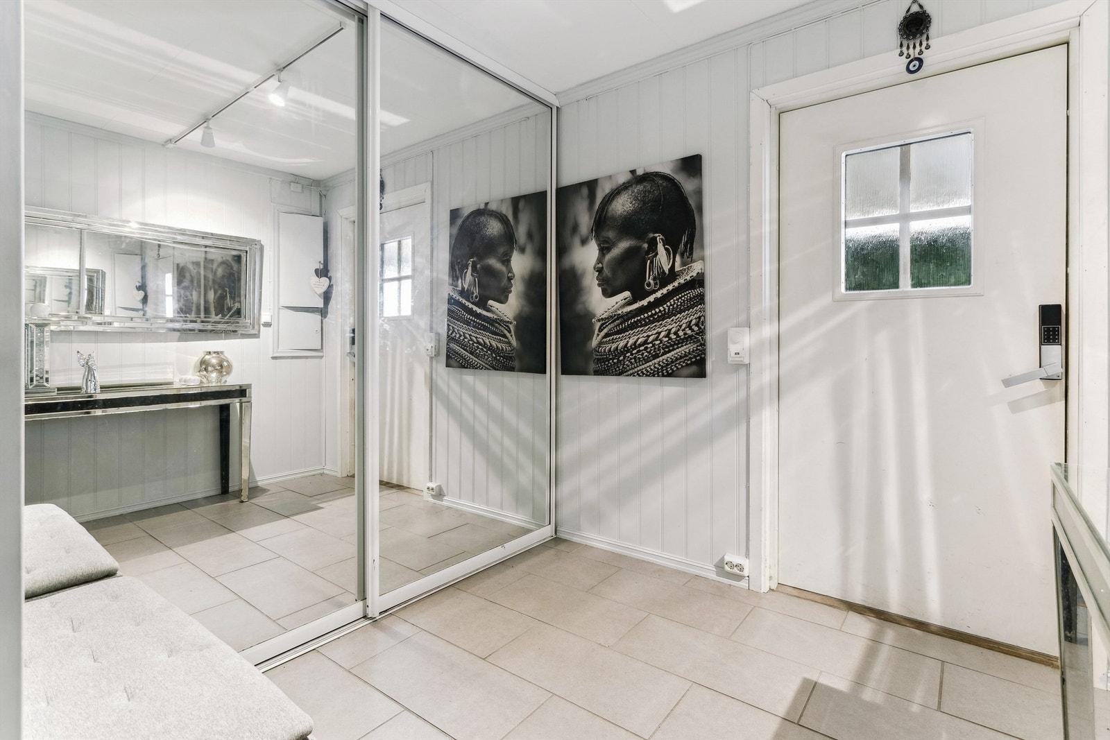 Romslig entré med stor skyvedørsgarderobe med speilfronter Galleribilde