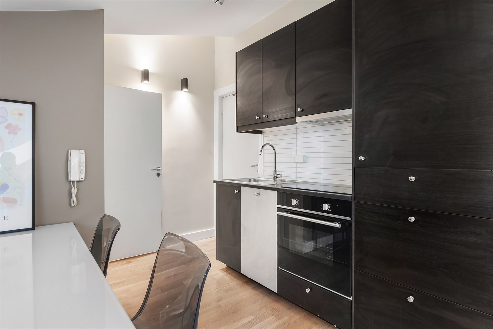 Kjøkken med integrert kjøleskap, vaskemaskin, komfyr og platetopp Galleribilde