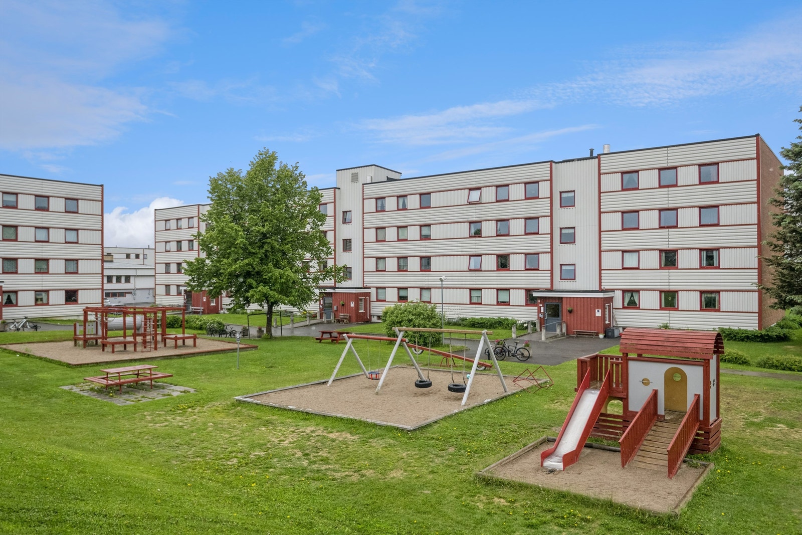 Felles uteområde i borettslaget, med sitteplasser og lekeapparater Galleribilde
