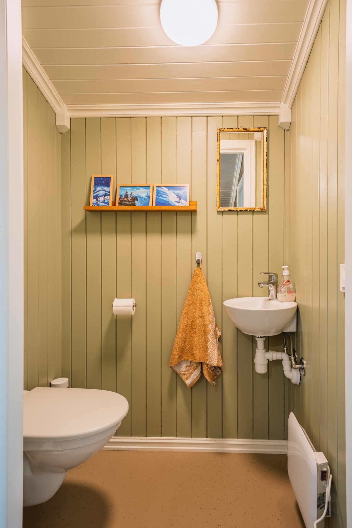 Vegghengt toalett, vask og panelovn. Galleribilde