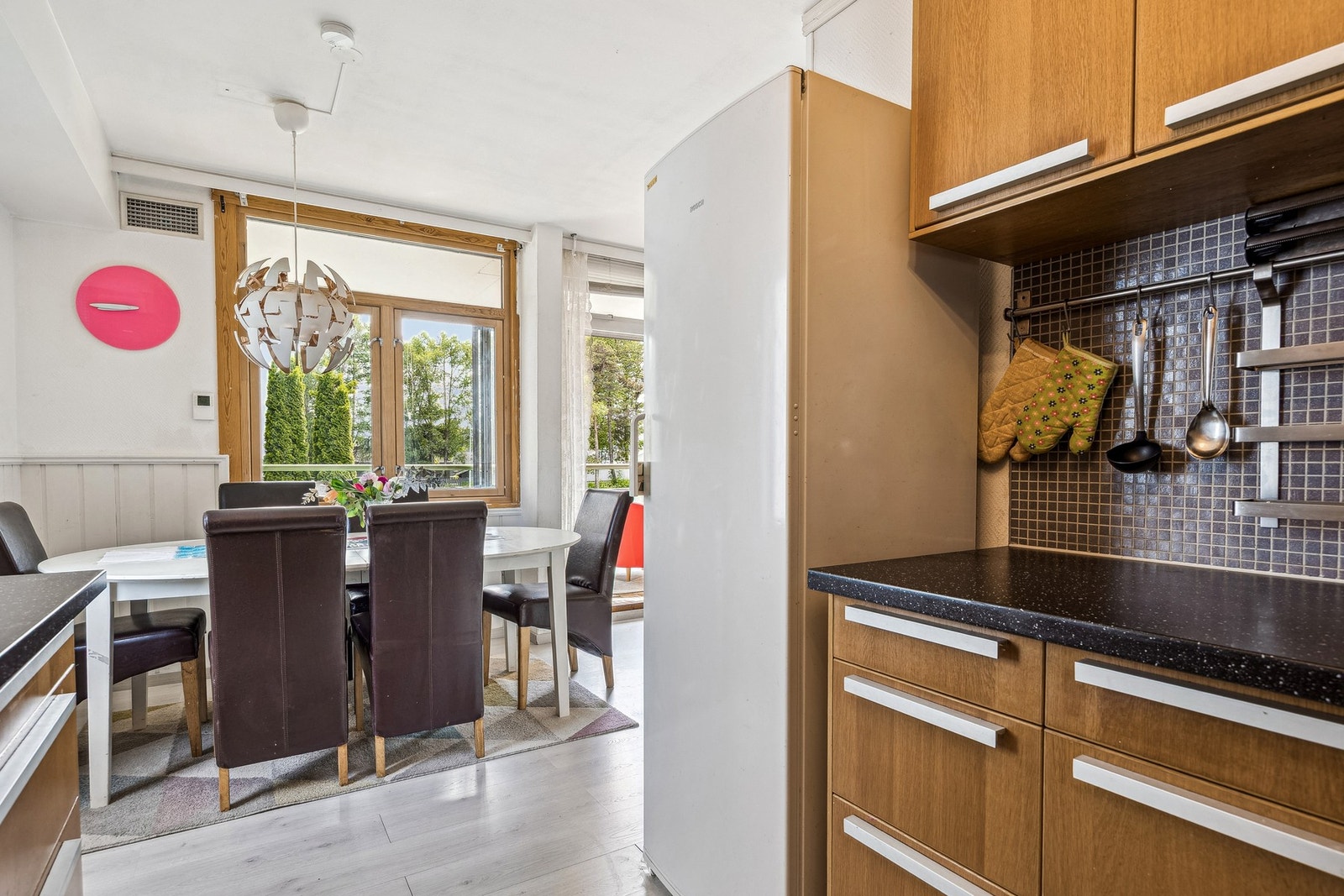 Det er god plass til en spisegruppe i den åpne løsningen mellom kjøkken og stue, som skaper en naturlig og sosial sone for måltider og samvær. Galleribilde