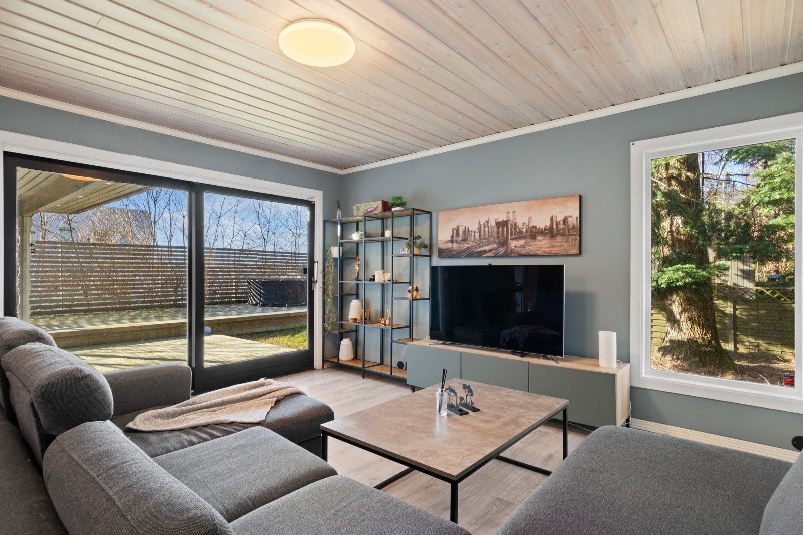 Hovedstuen har godt lysinnslipp via store vinduer i to retninger, inkludert en skyvedør til den herlige terrassen i hagen. Galleribilde