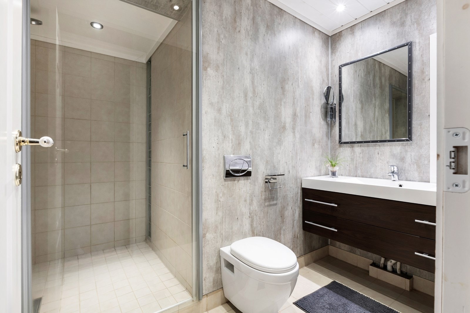 Delikat bad i 1.etasje med varmekabler i gulv. Rommet har innredning med nedfelt servant, toalett og dusjvegger/hjørne. Det er elektrisk styrt vifte. Galleribilde