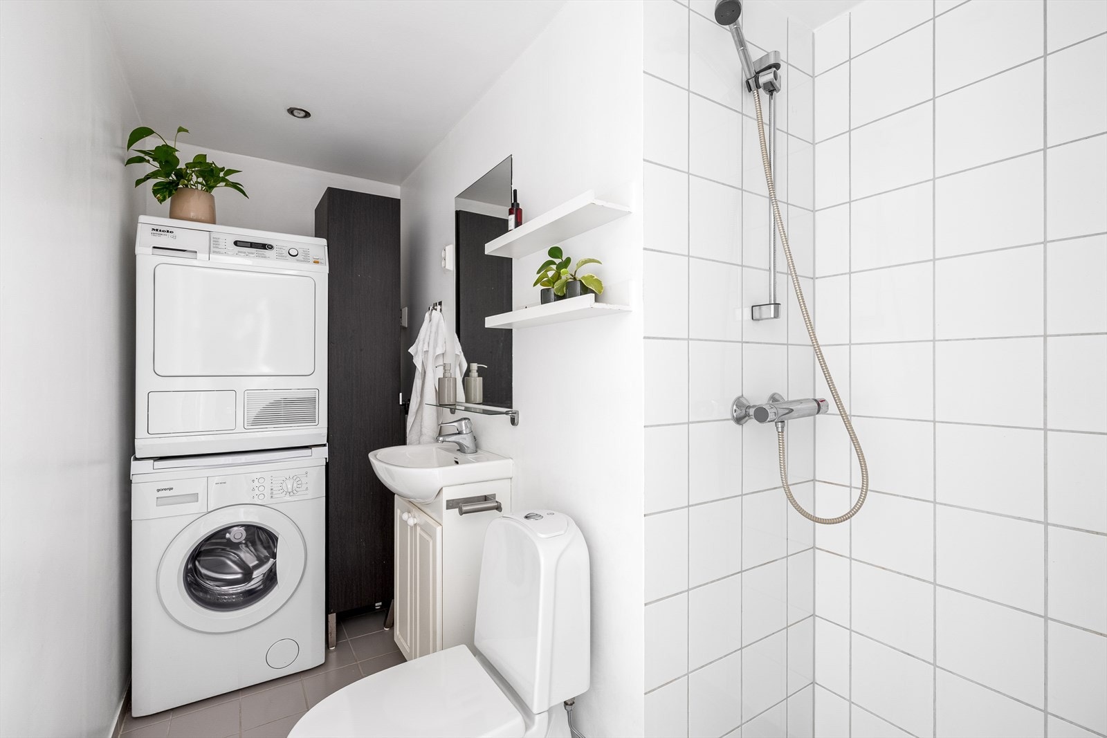 Badet er praktisk innredet med heldekkende servant, gulvstående toalett og dusj. Galleribilde