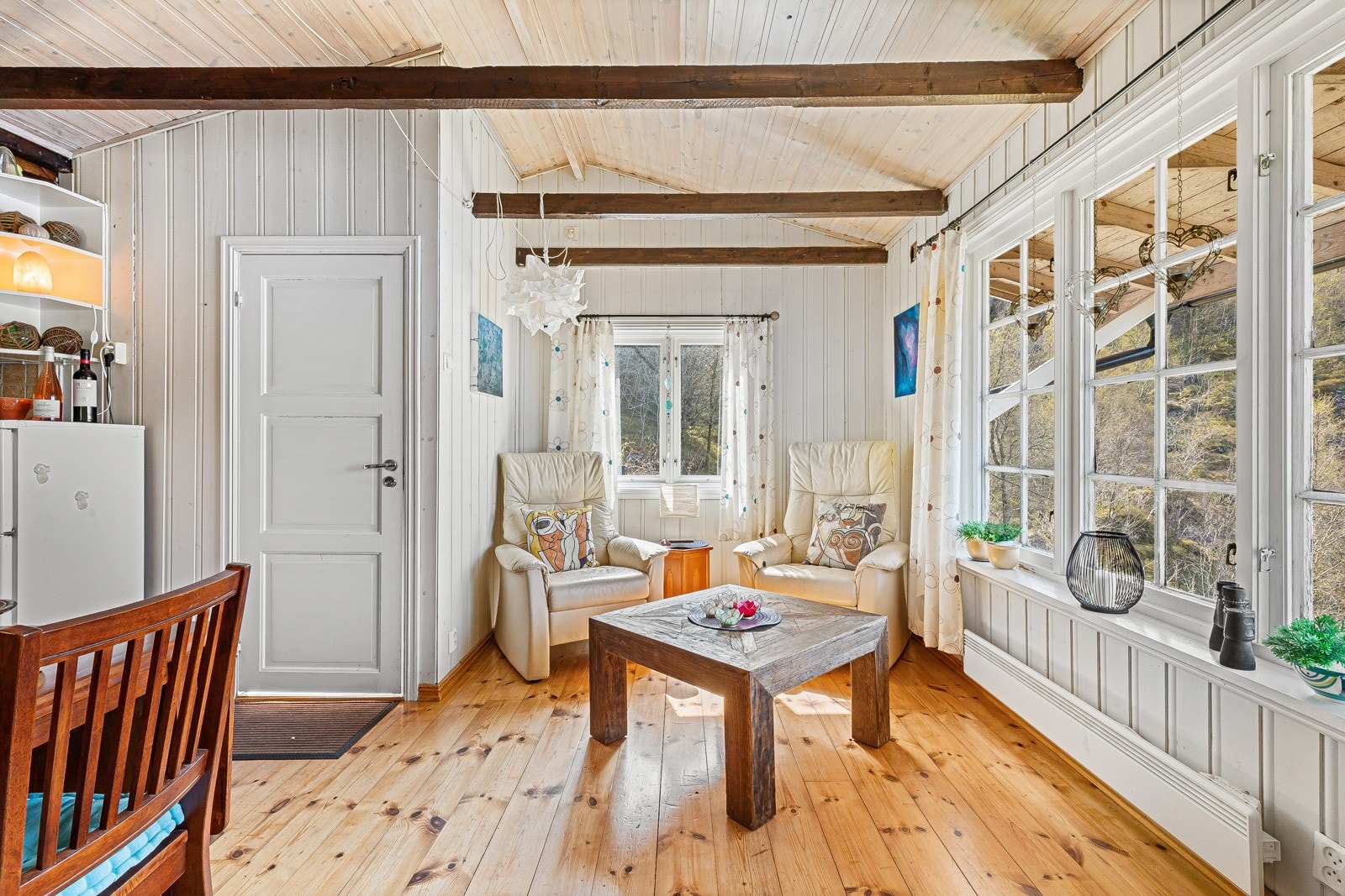 - Store vindusflater slipper lys og utsikt inn i hytten - Galleribilde