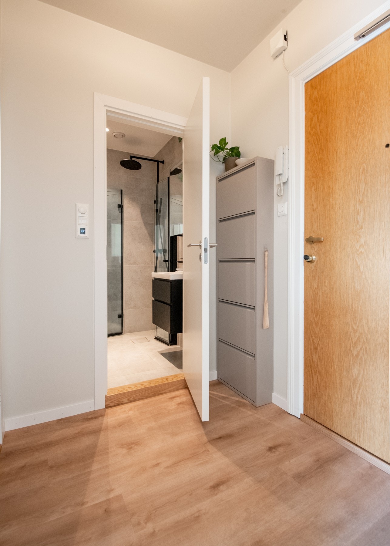 Entréens overflater er holdt i lyse farger med lyse, malte vegger og laminatgulv som gir et moderne og rent uttrykk. Galleribilde