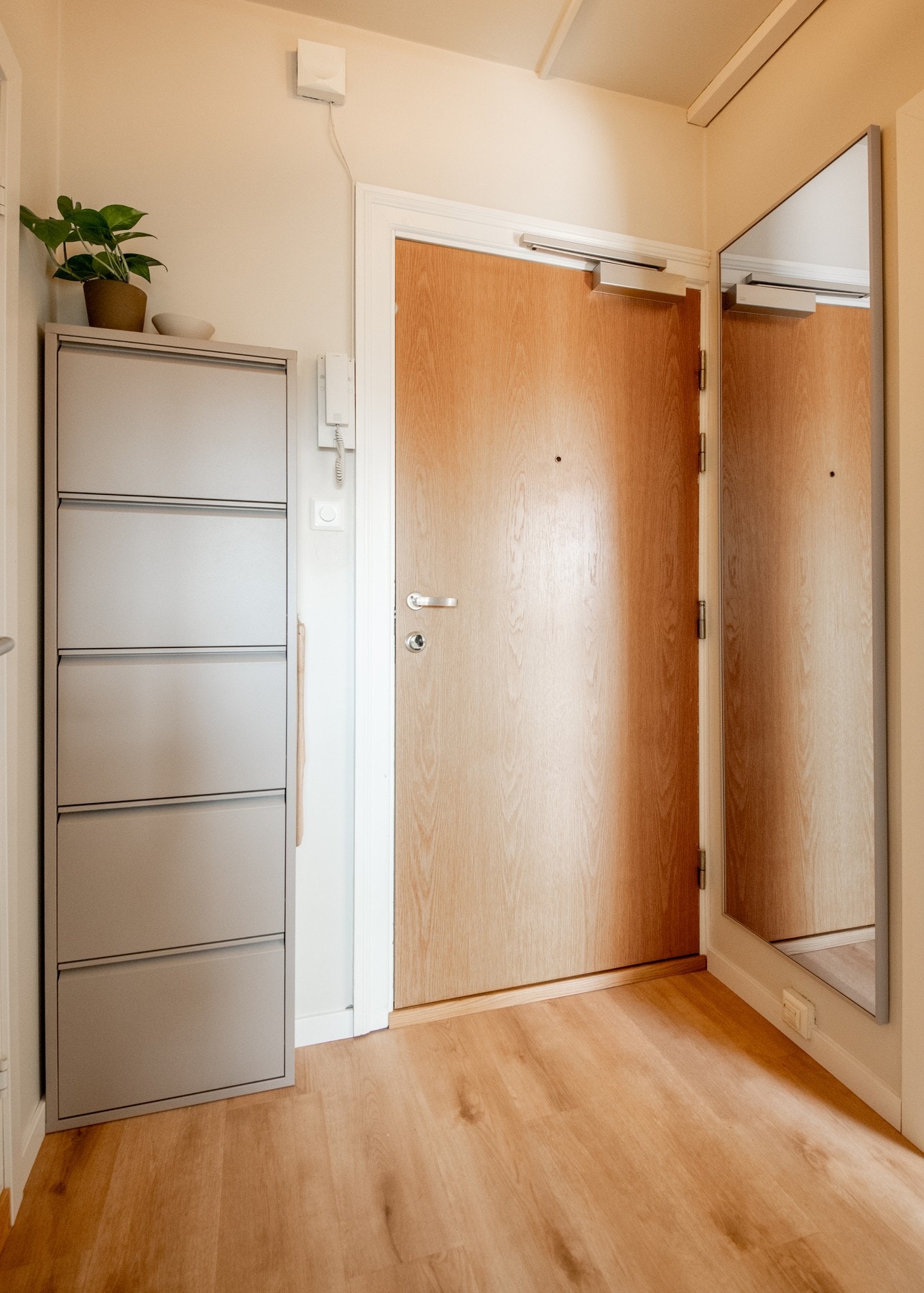 Leiligheten ligger i byggets femte etasje, og entréen ønsker deg velkommen med en lys og luftig atmosfære. Galleribilde