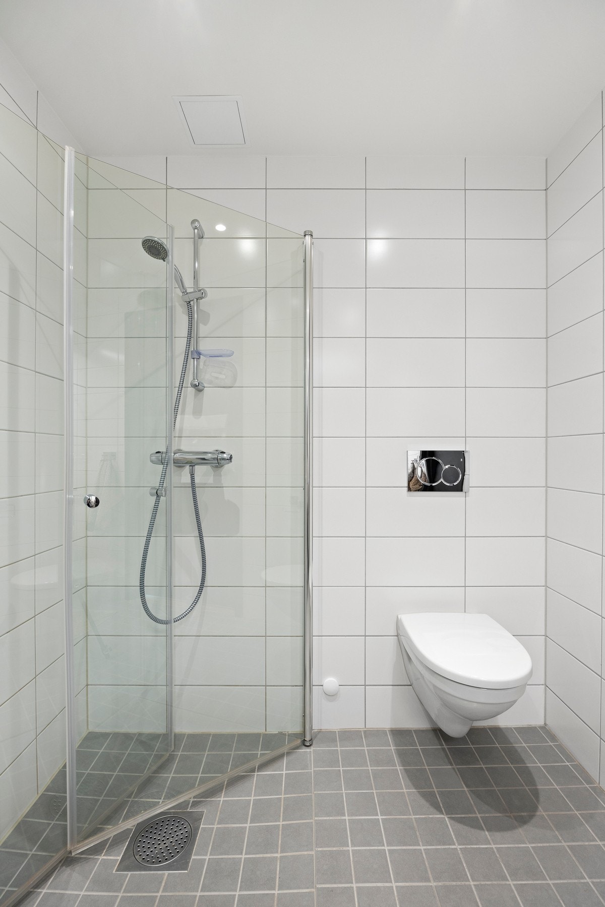 Praktisk dusjsone med innfellbare glassdører og moderne dusjarmatur med hånddusj. Galleribilde