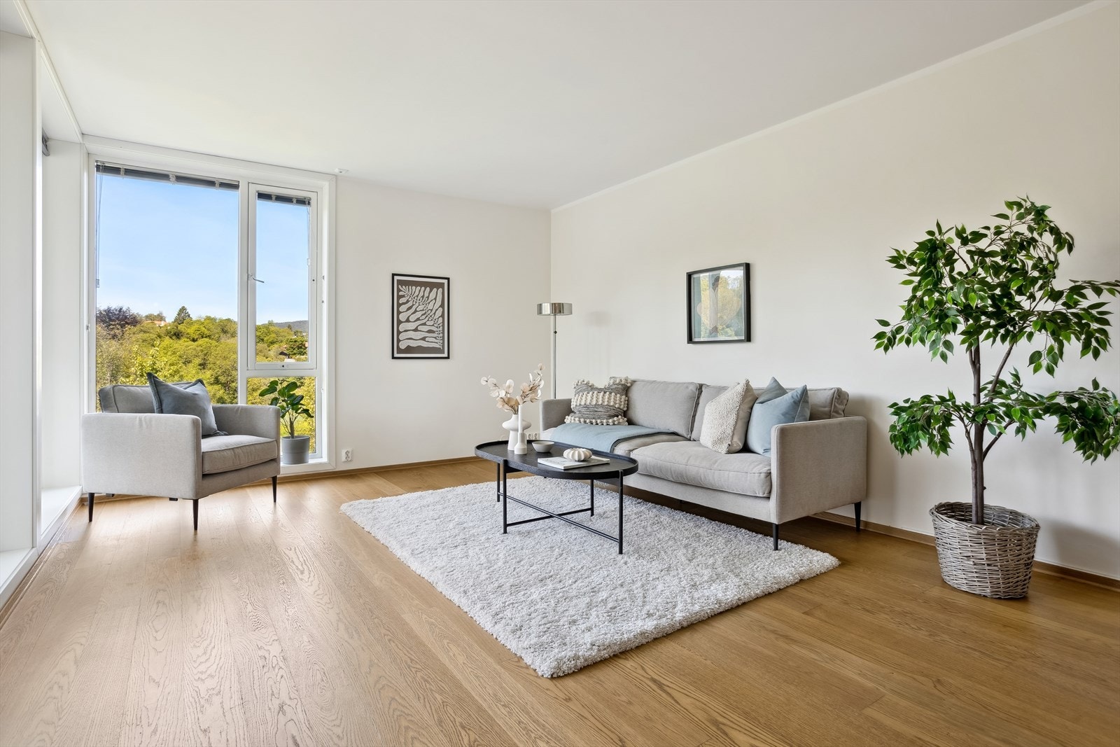 Store vindusflater gir rikelig med naturlig lys. Stuen har god plass til både sofagruppe og spisebord. Galleribilde