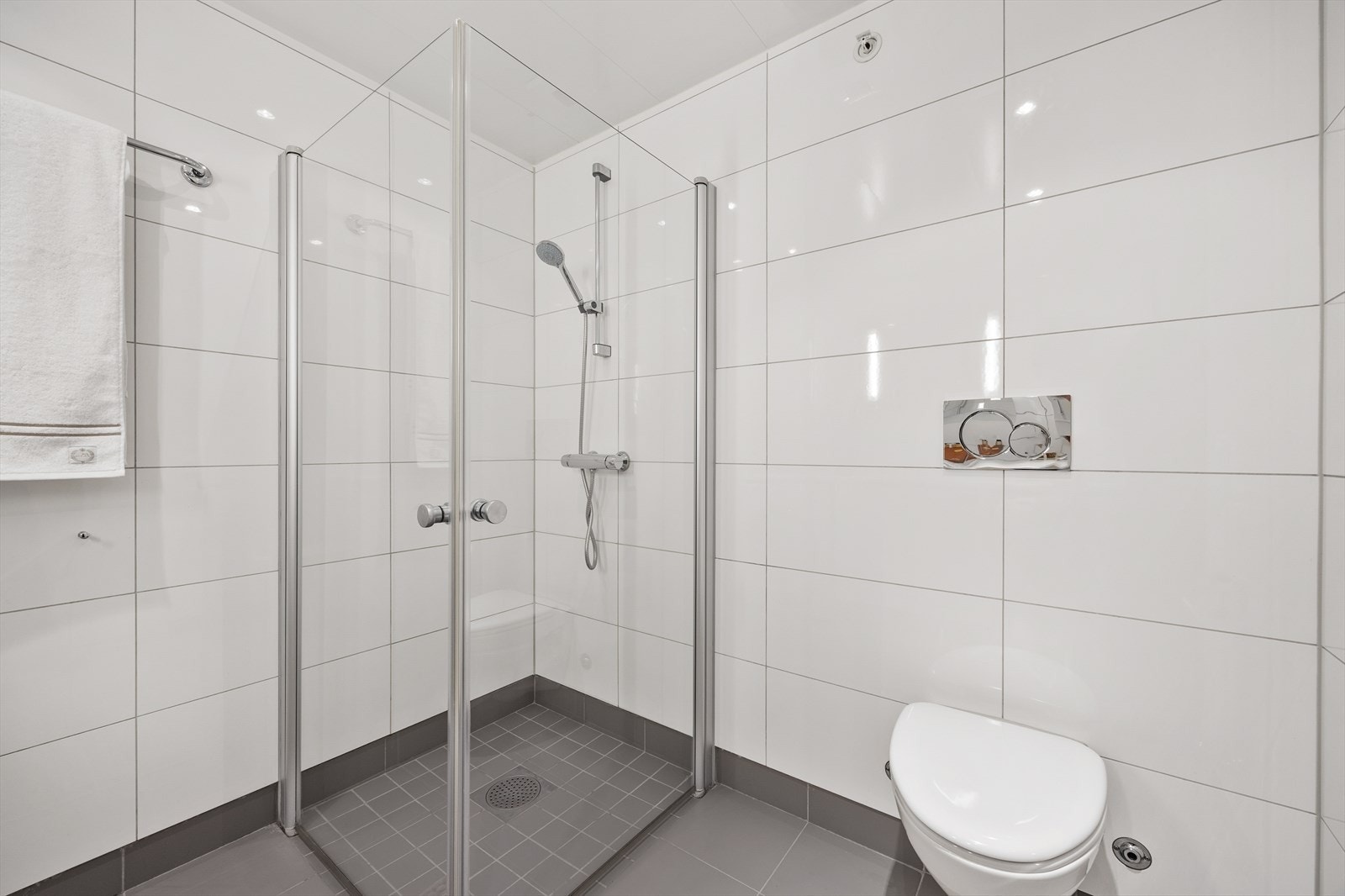 Dette badet er utstyrt med dusjhjørne med innfellbare glassvegger, vegghengt wc og servantinnredning med under- og sideskap Galleribilde
