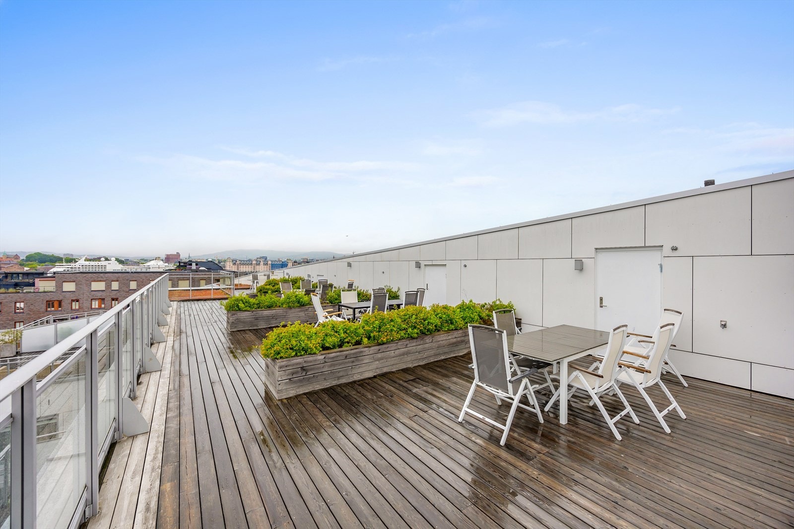 Felles takterrasse med sittegrupper og beplantning, perfekt for sosiale sammenkomster Galleribilde