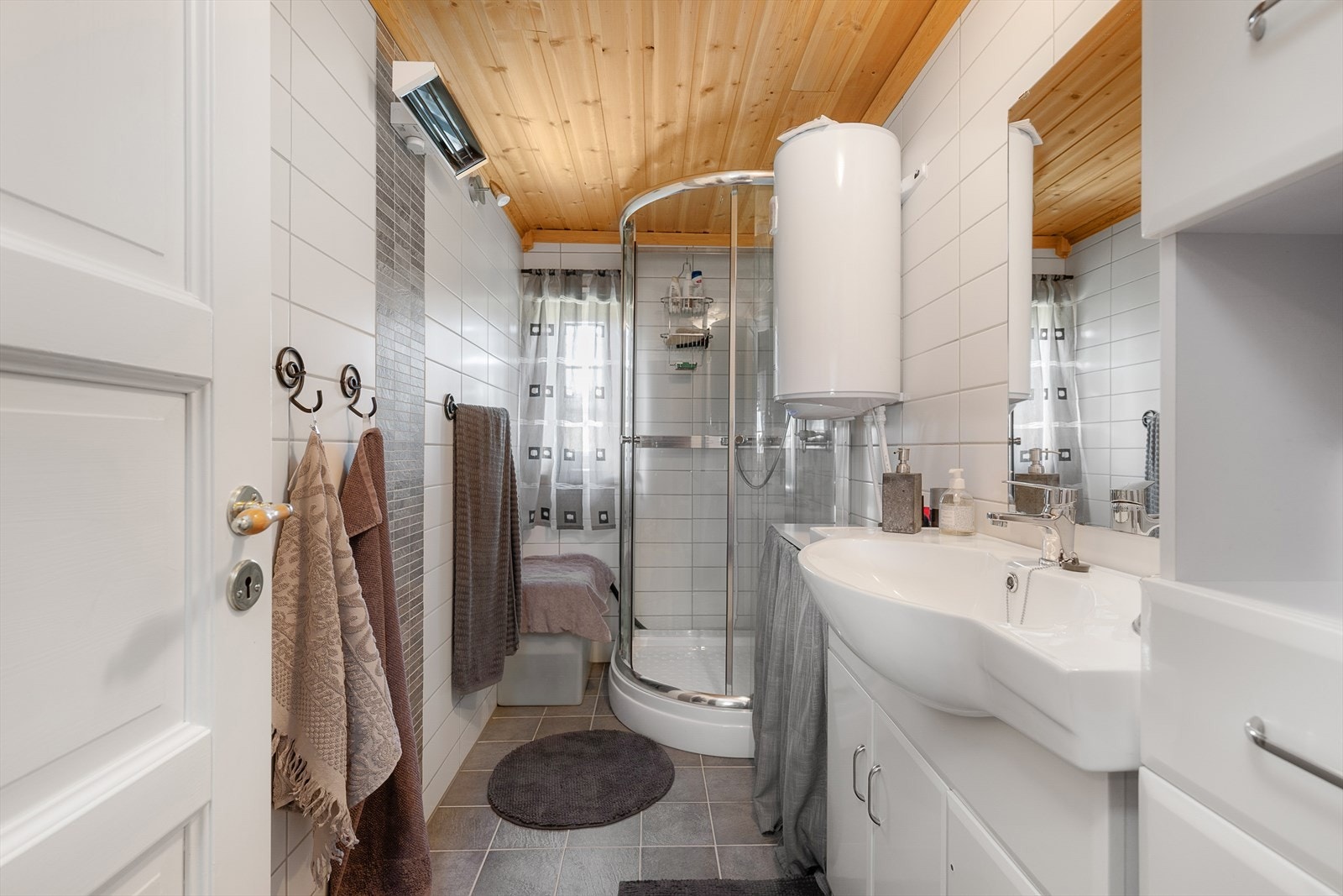 Flislagt baderom med dusj og servant. Galleribilde