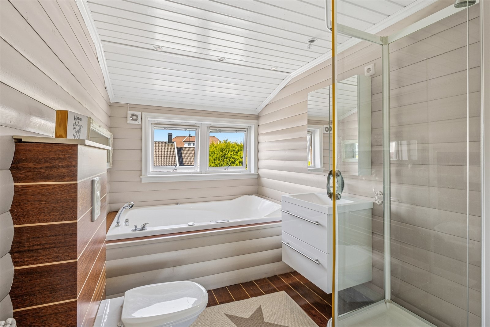 Badet i 2 etg har badekar, vegghengt toalett, servant med underskuffer, speilskap og dusjkabinett. (Godkjent som bod) Galleribilde