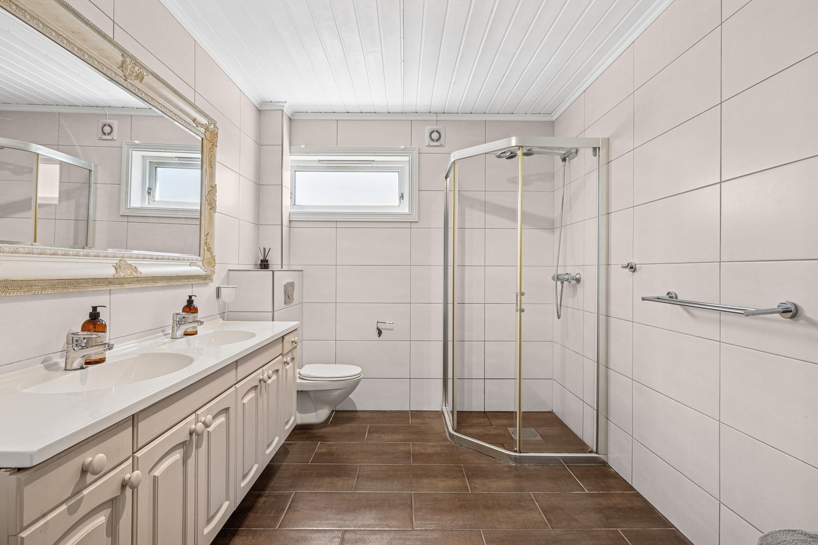 Badet ligger i 1 etg og er utstyrt med vegghengt toalett, servant med underskap, dusjnisje. Fliser på vegg og gulv. Galleribilde