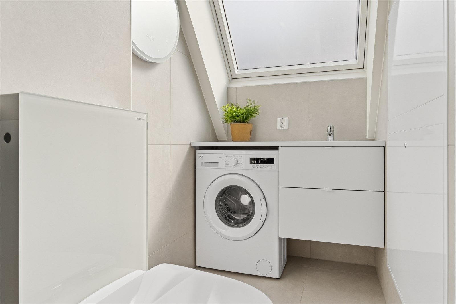 Videre er badet innredning med servant, samt opplegg for vaskemaskin. Galleribilde