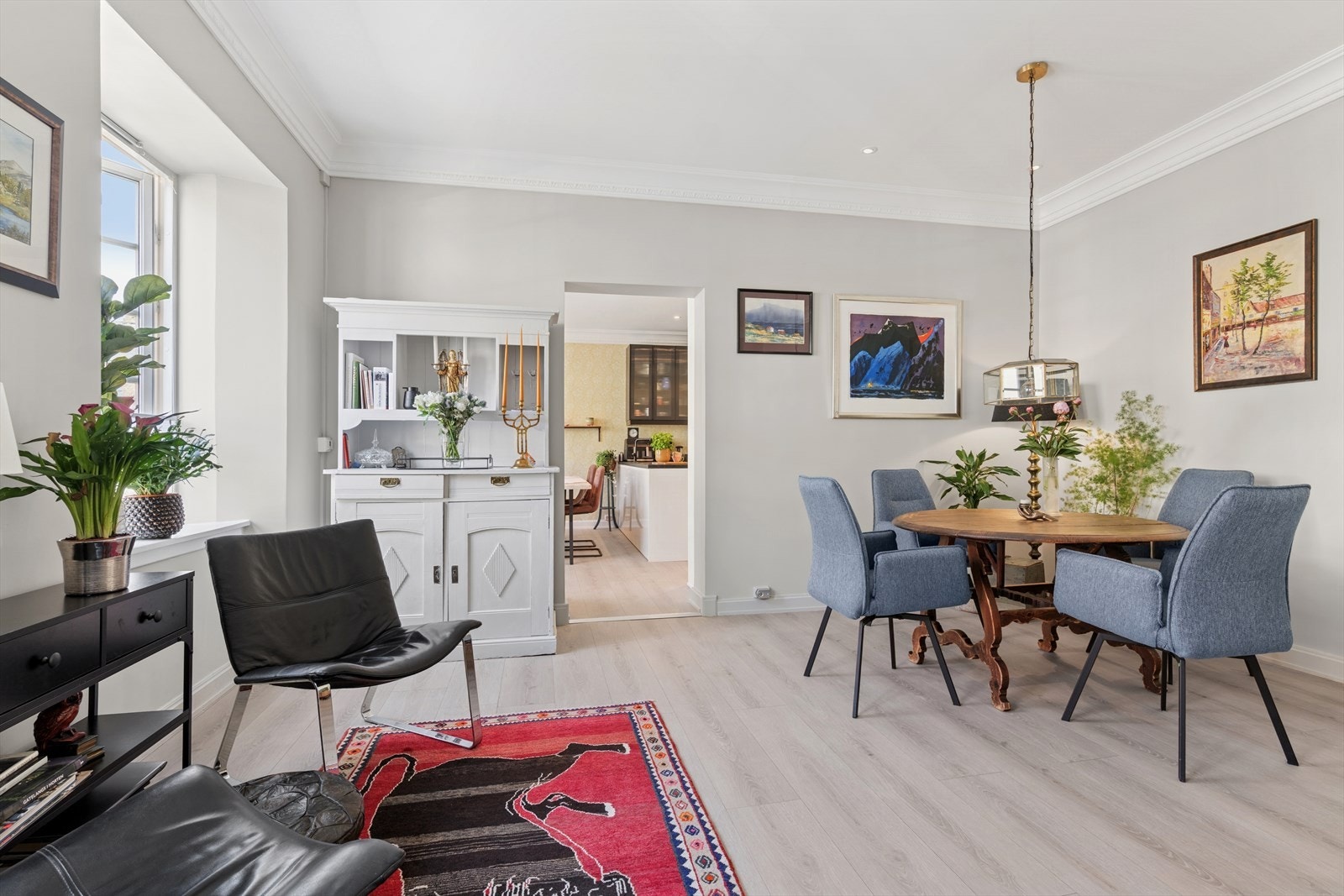 Stua rommer flere sittegrupper og stort spisebord. Galleribilde