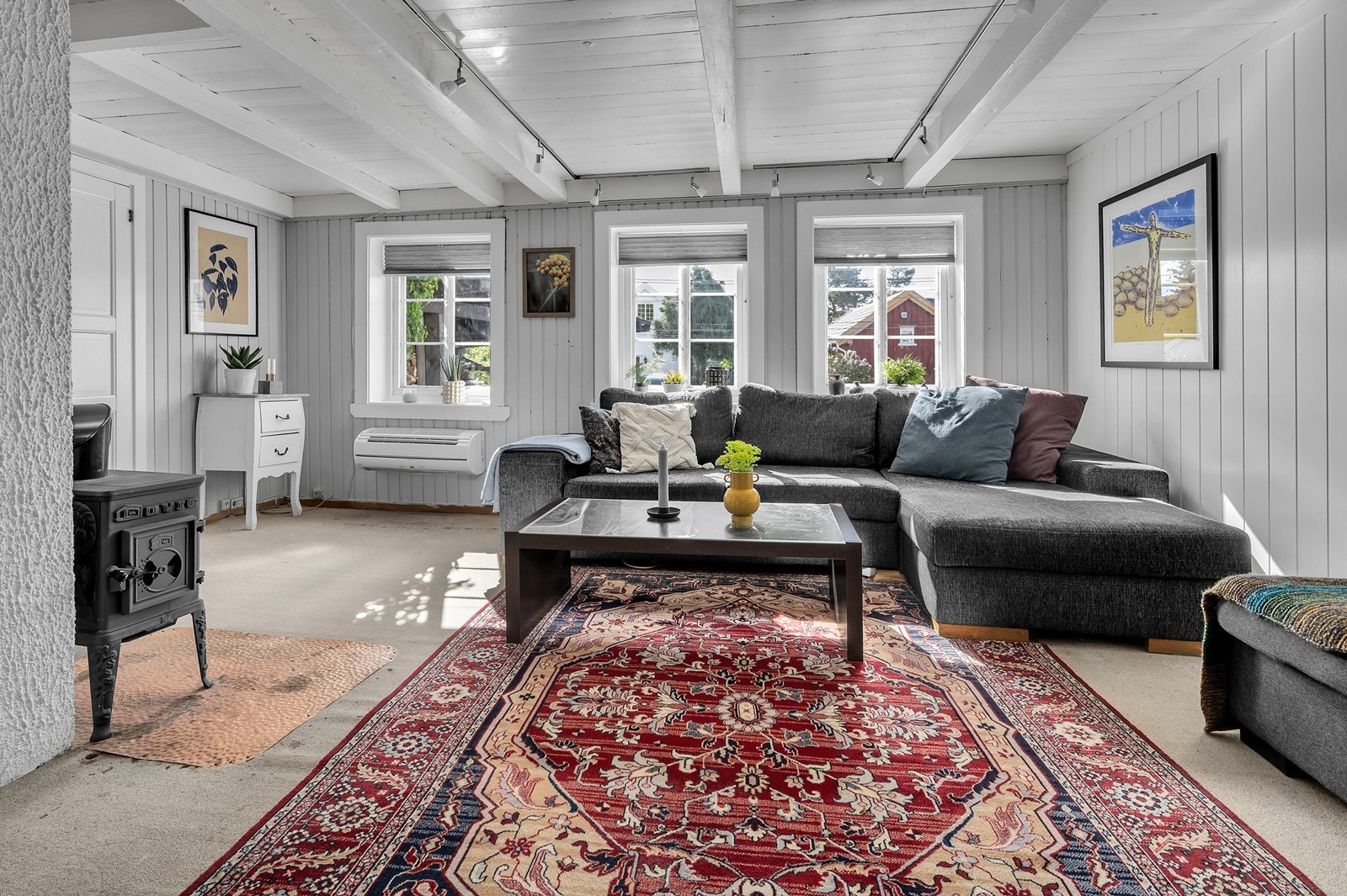 Stuen er innredet med eldre vedovn og varmepumpe. Galleribilde