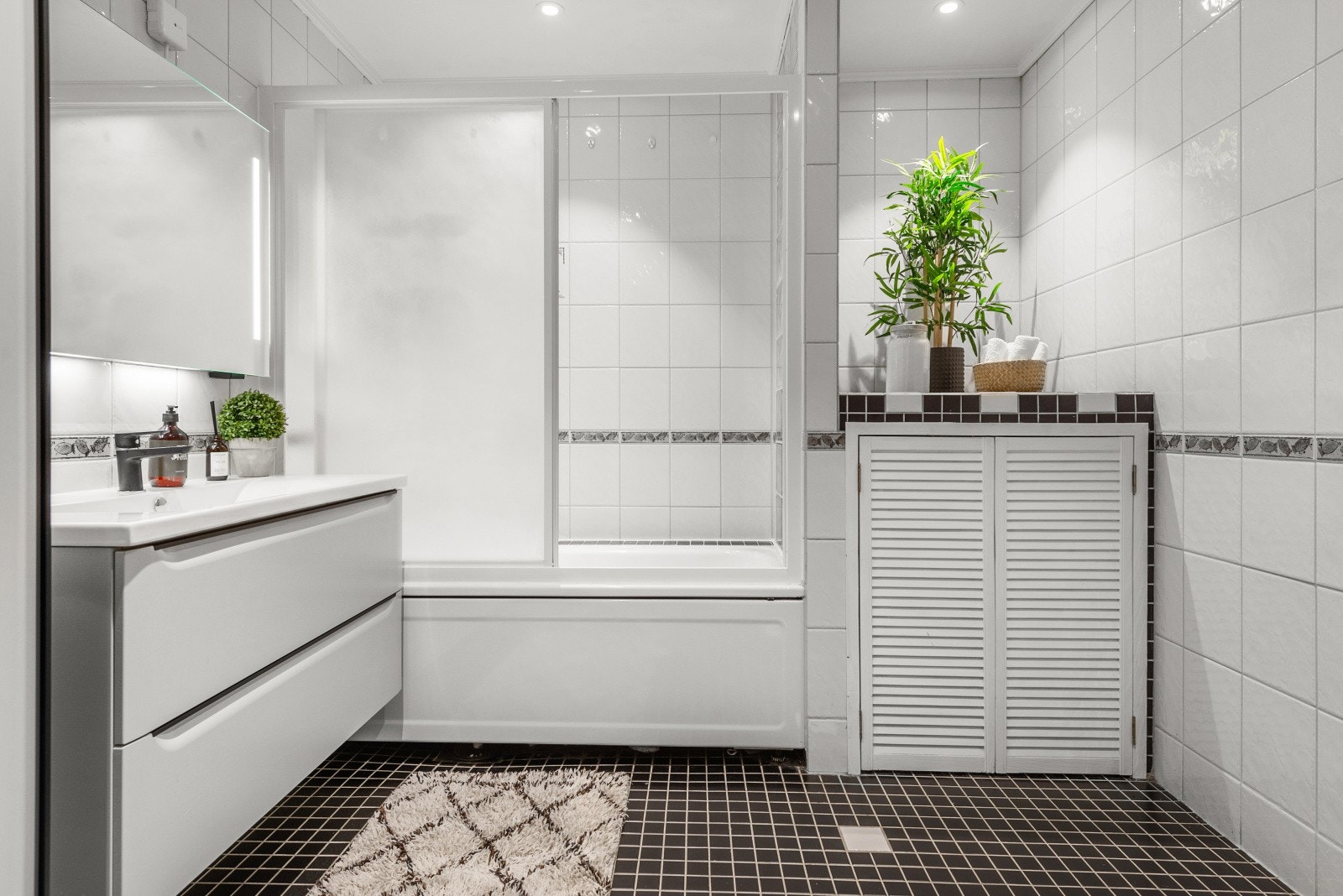 Badet er innredet med servant, badekar med dusj, klosett, varmtvannsbereder og mekanisk avtrekk Galleribilde